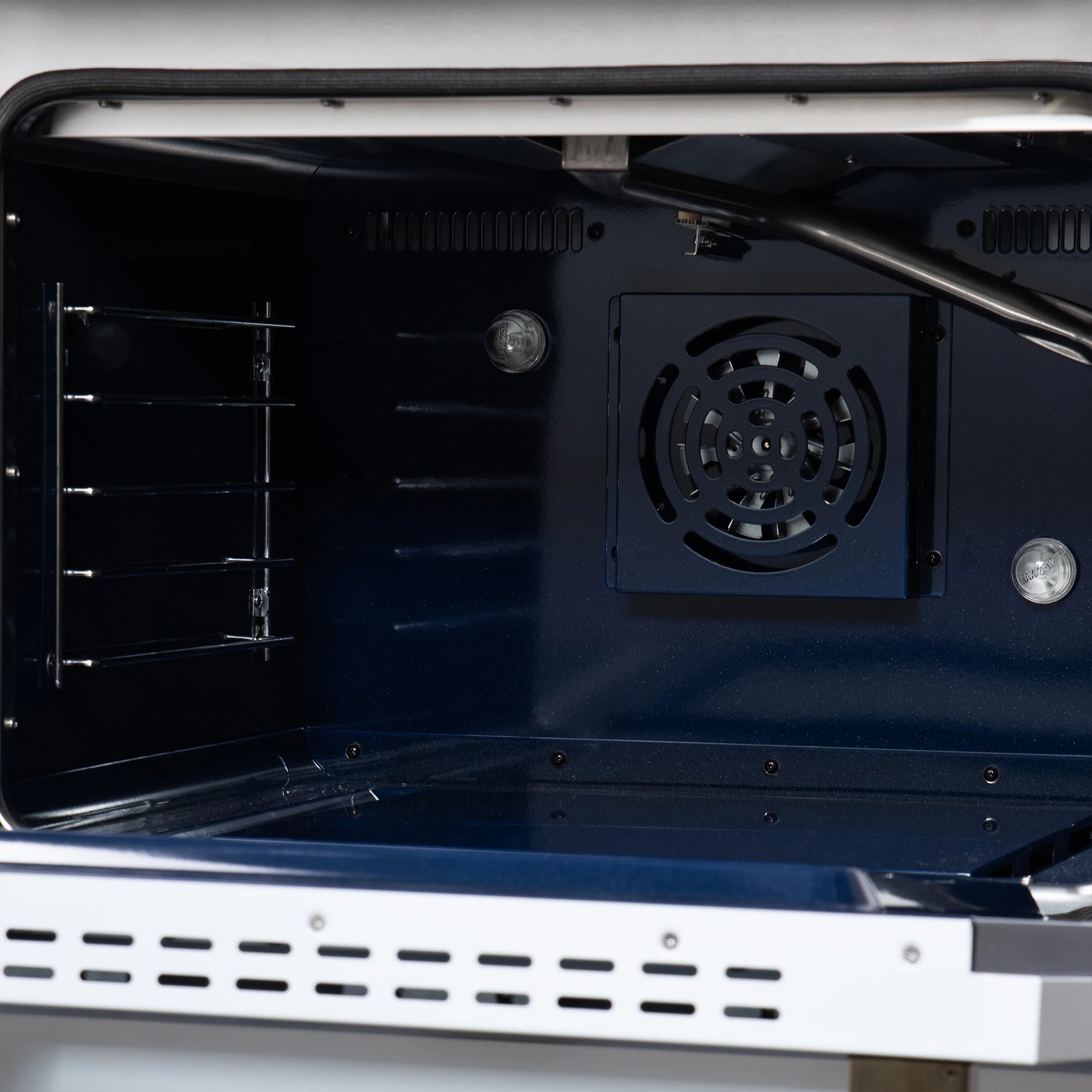 Convection oven fan inside cavity with black blower housing and rear vent.