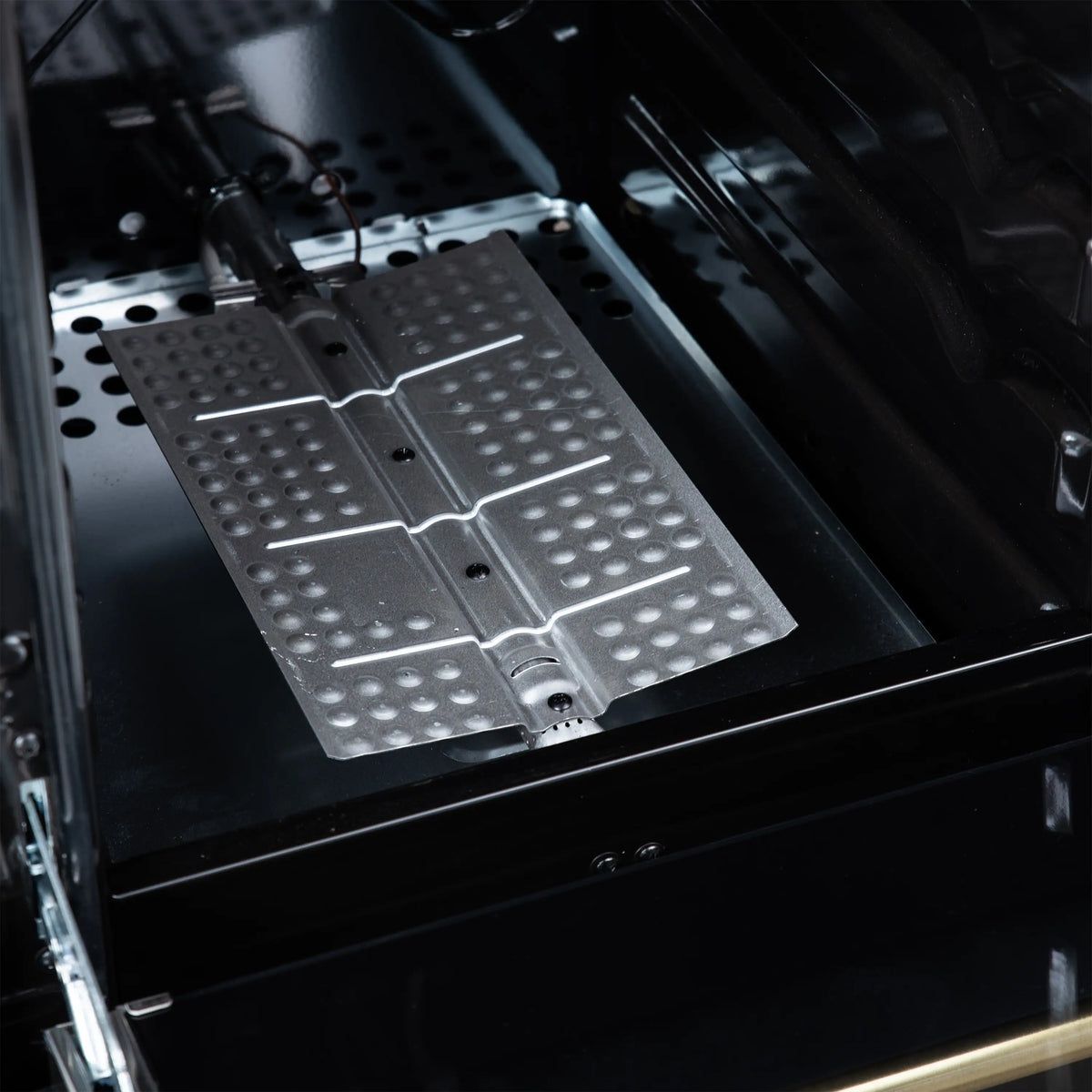 Gas range oven burner covers with perforated stainless panels in black cavity