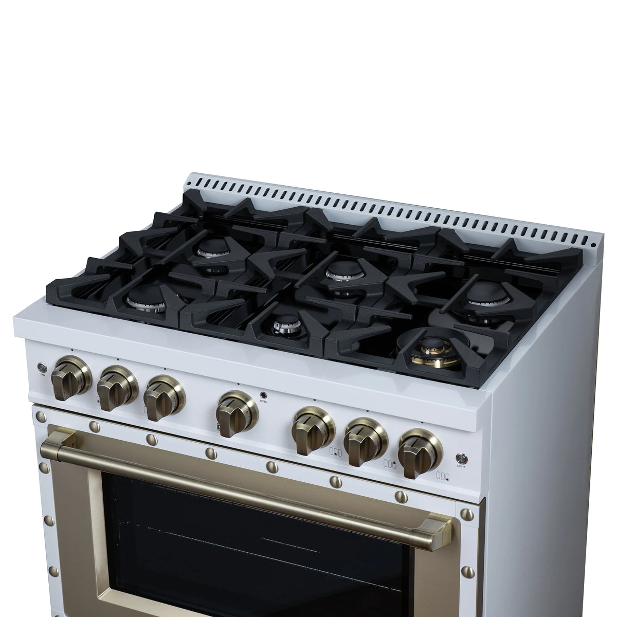 White gas range cooktop with six black grates and brass knobs in a close-up view