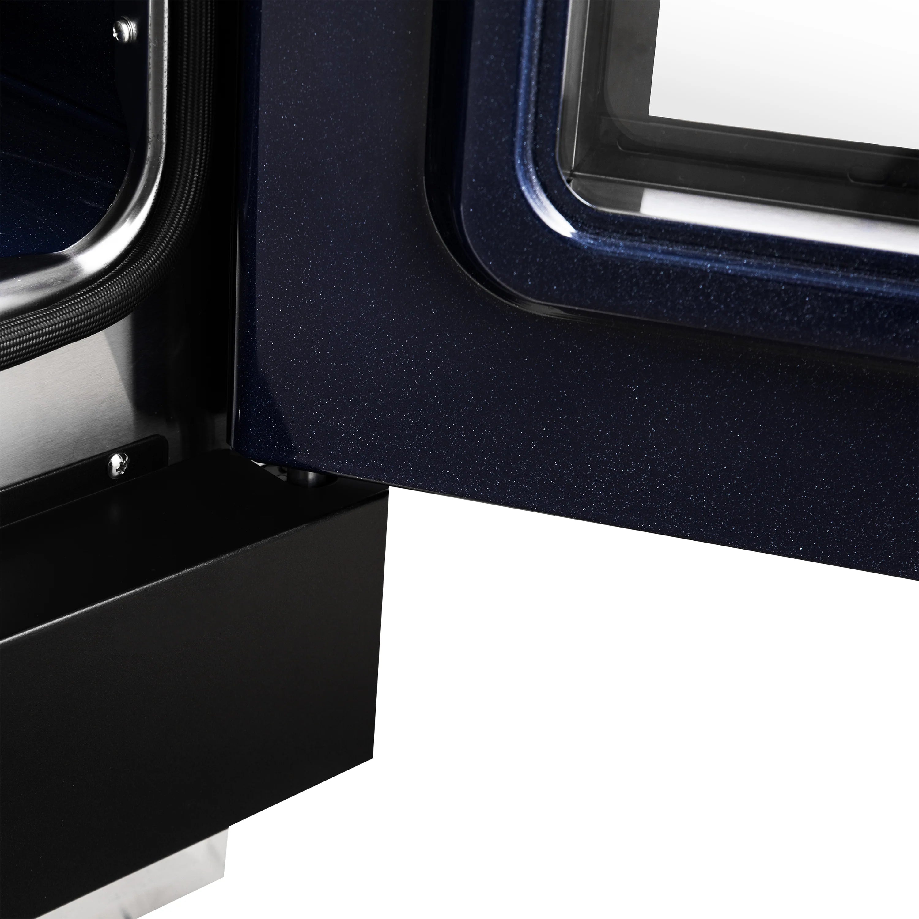 Gas range oven door open with visible dark interior and brass-finish handle