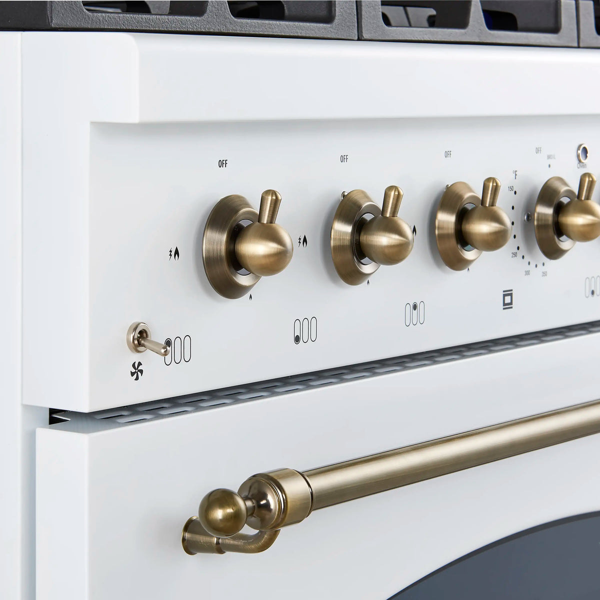 Control panel with brass knobs and markings, plus a long brass cooktop rail on white range