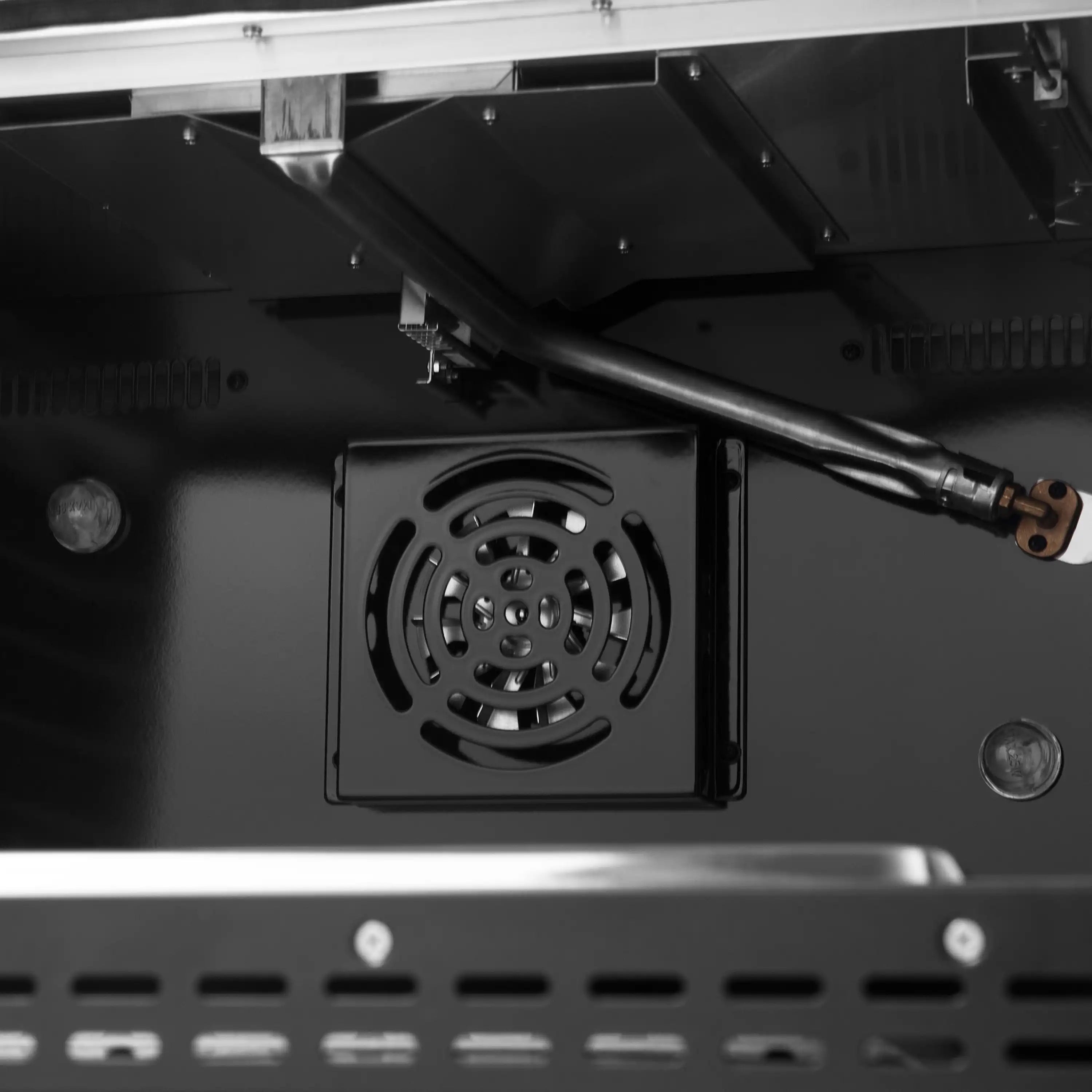Black gas oven interior with rear circular fan vent and side heat shield