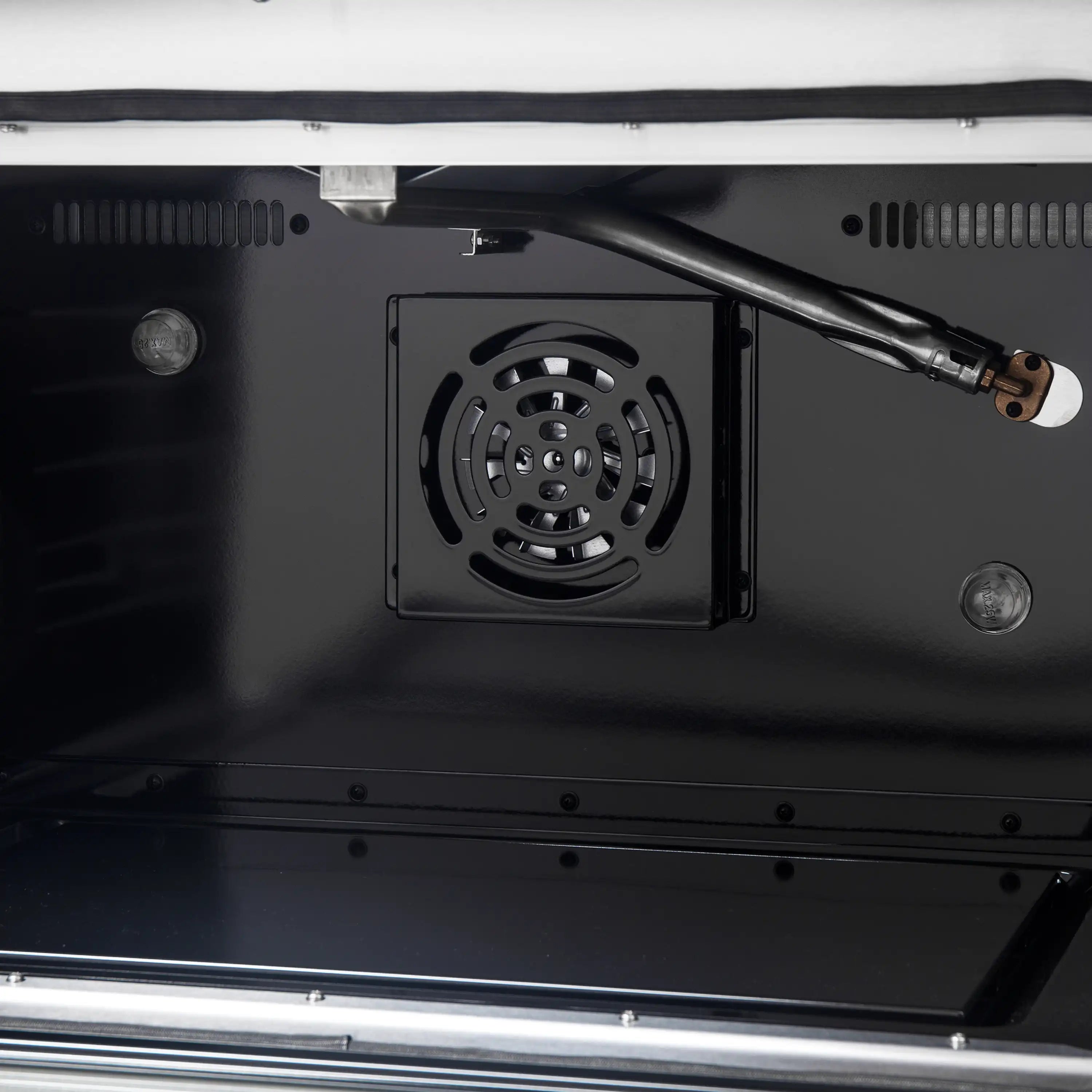 Black gas oven interior showing rear fan vent and metal burner tubes