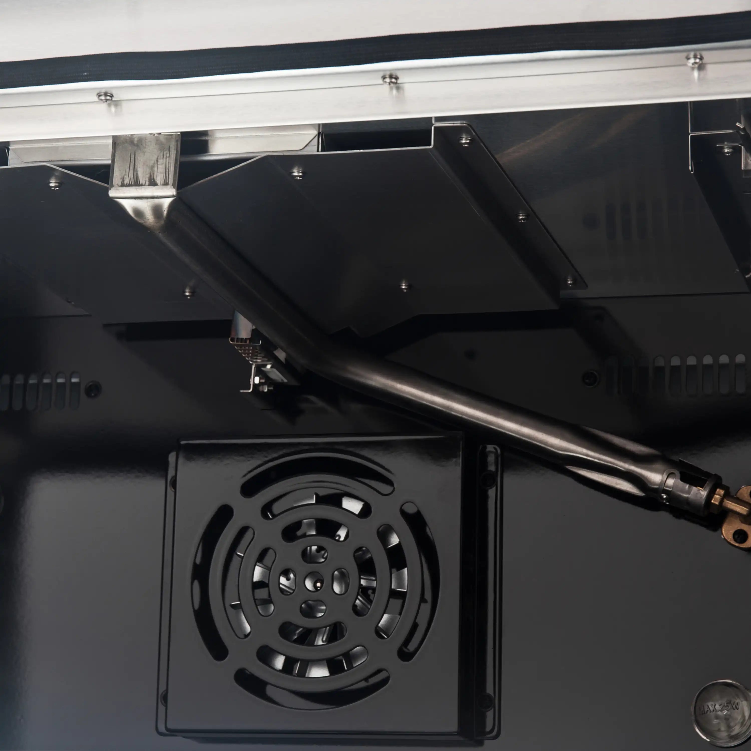 Oven interior with burner opening and stainless igniter tube, part of white gas range.