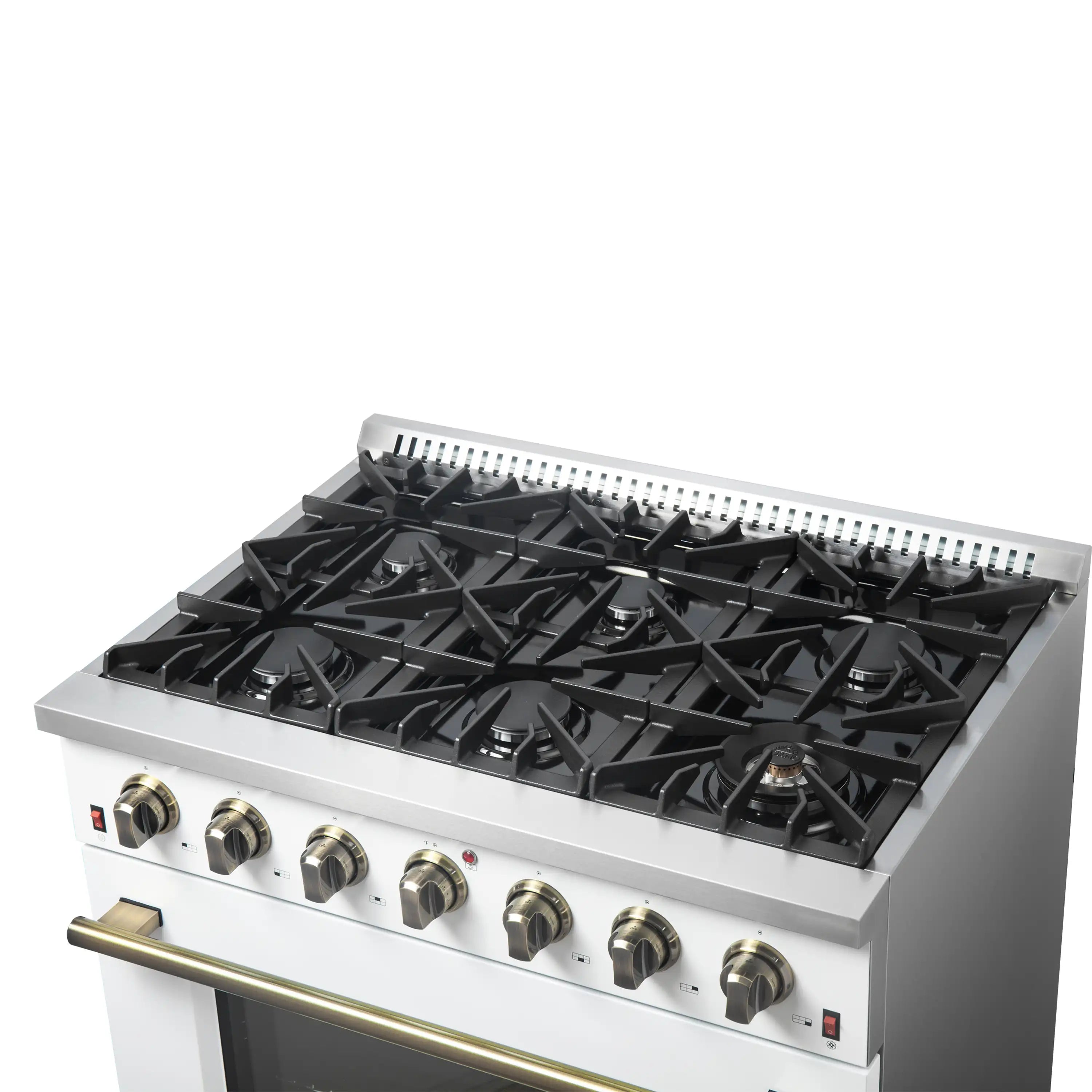 White gas cooktop with black grates and brass-trim control knobs, angled view.