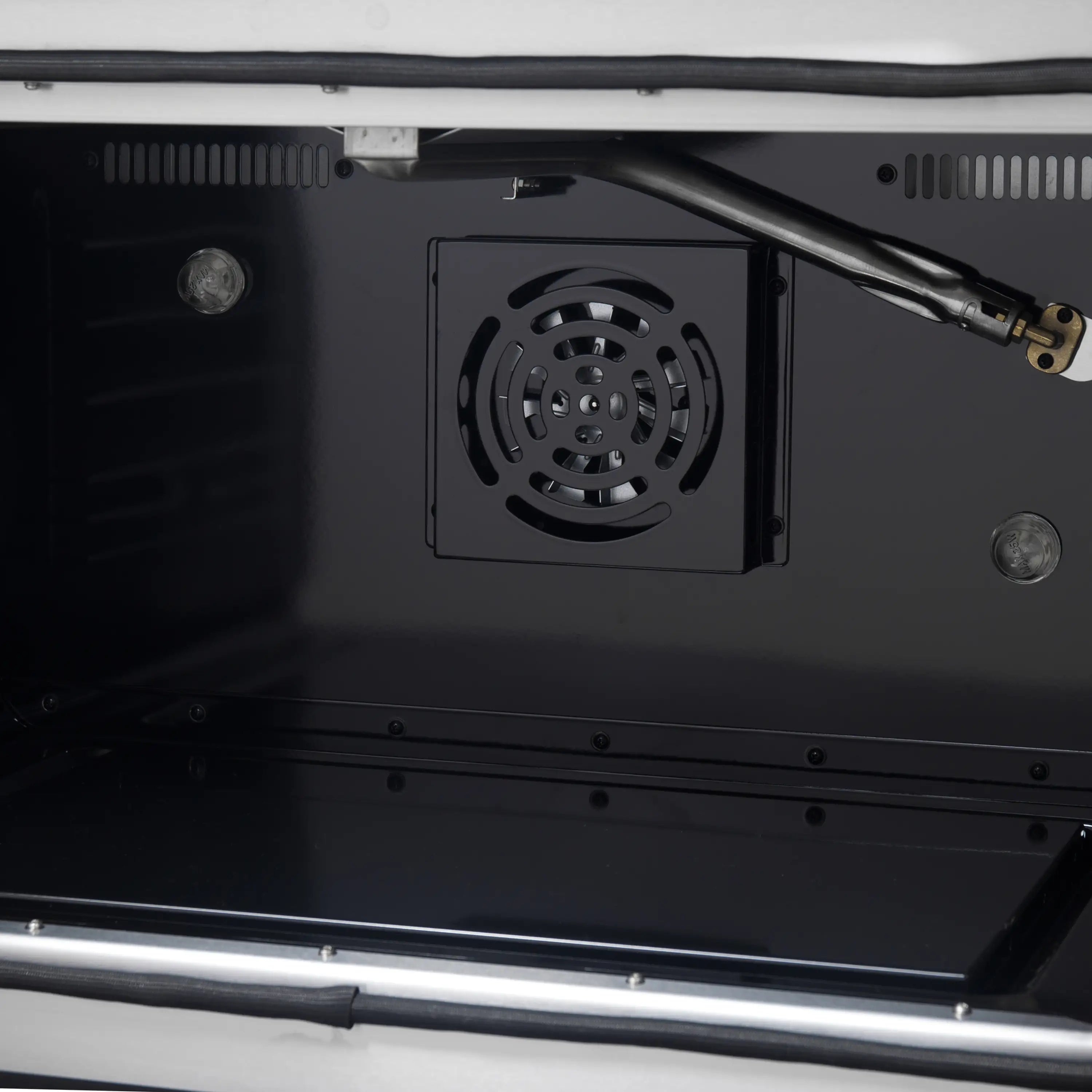 Black convection oven interior with cooling fan housing and heating elements