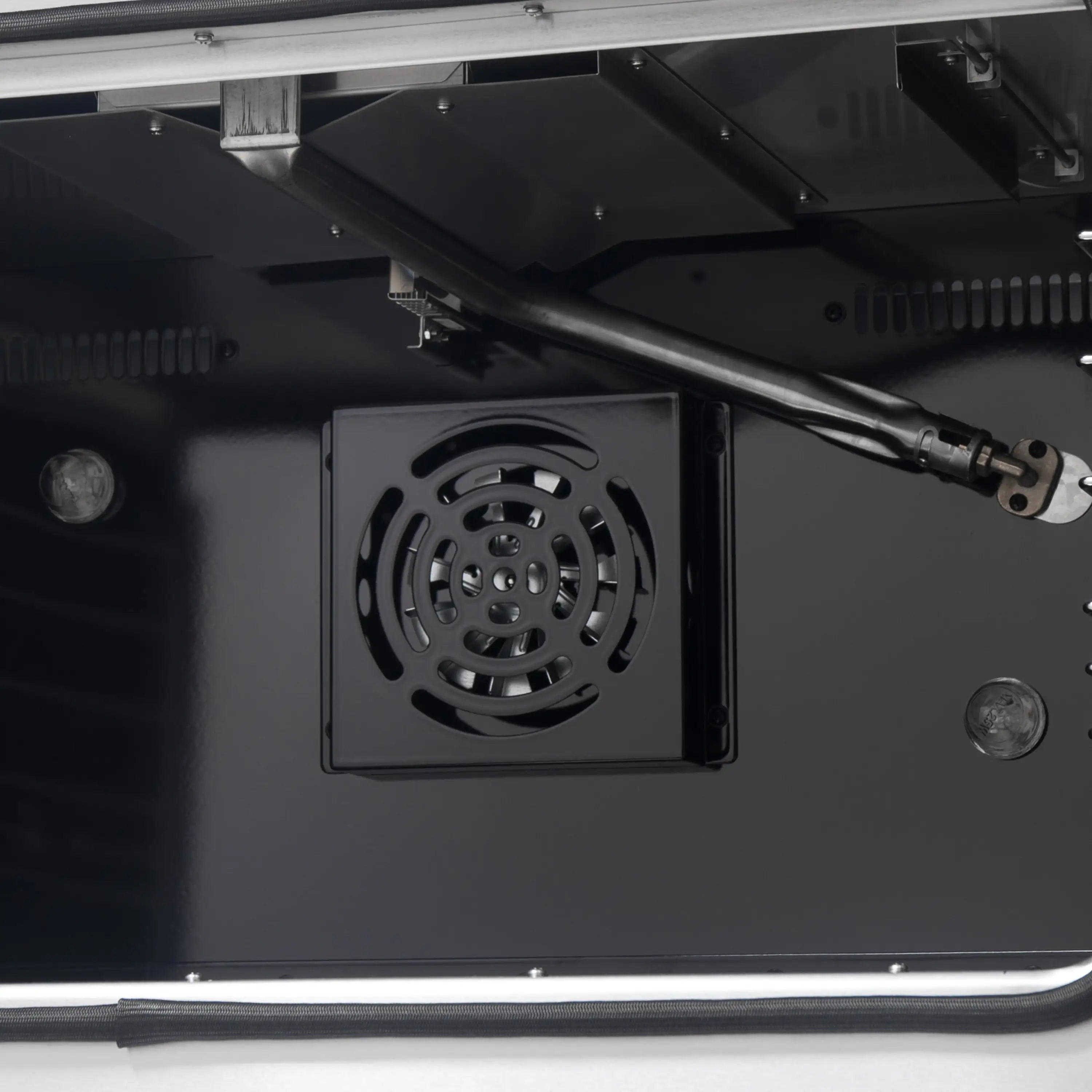 Gas oven rear ventilation grille with fan in black interior cavity.