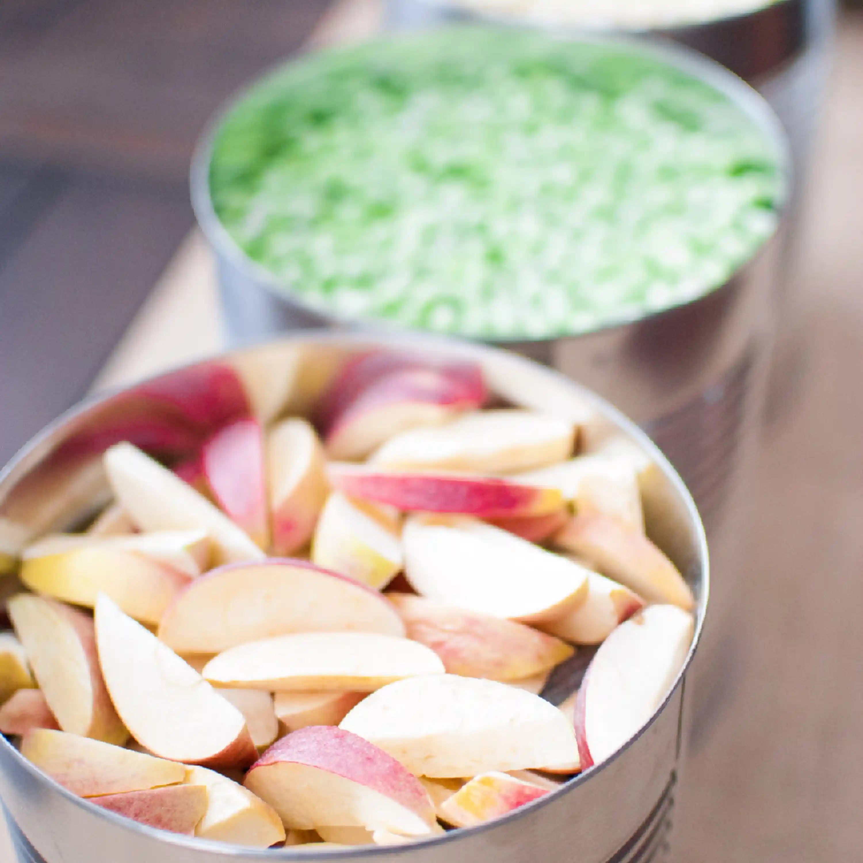 Bowls of sliced freeze-dried fruit, pale peach and pink wedges