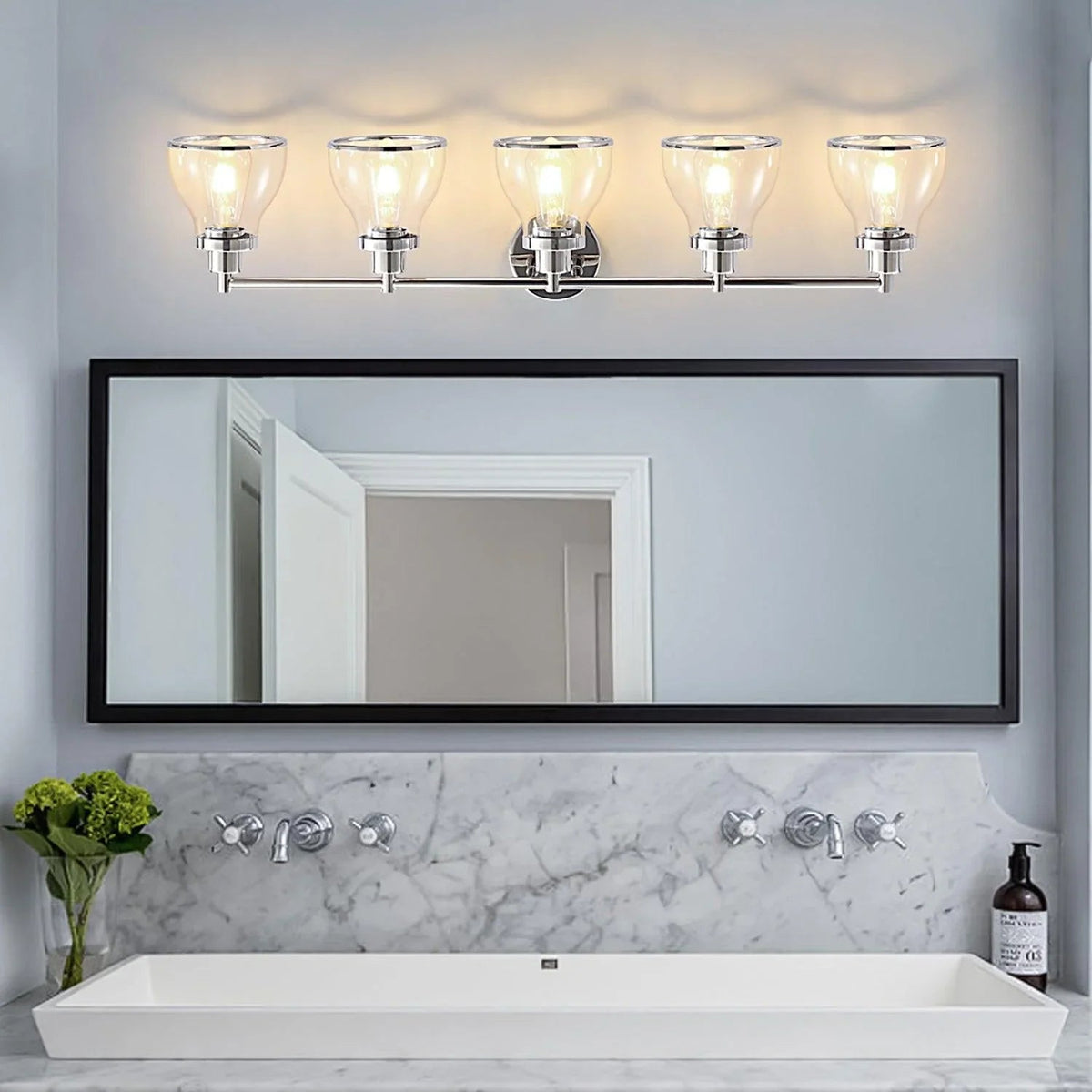 Polished nickel 5-light vanity light with clear glass shades over a vanity