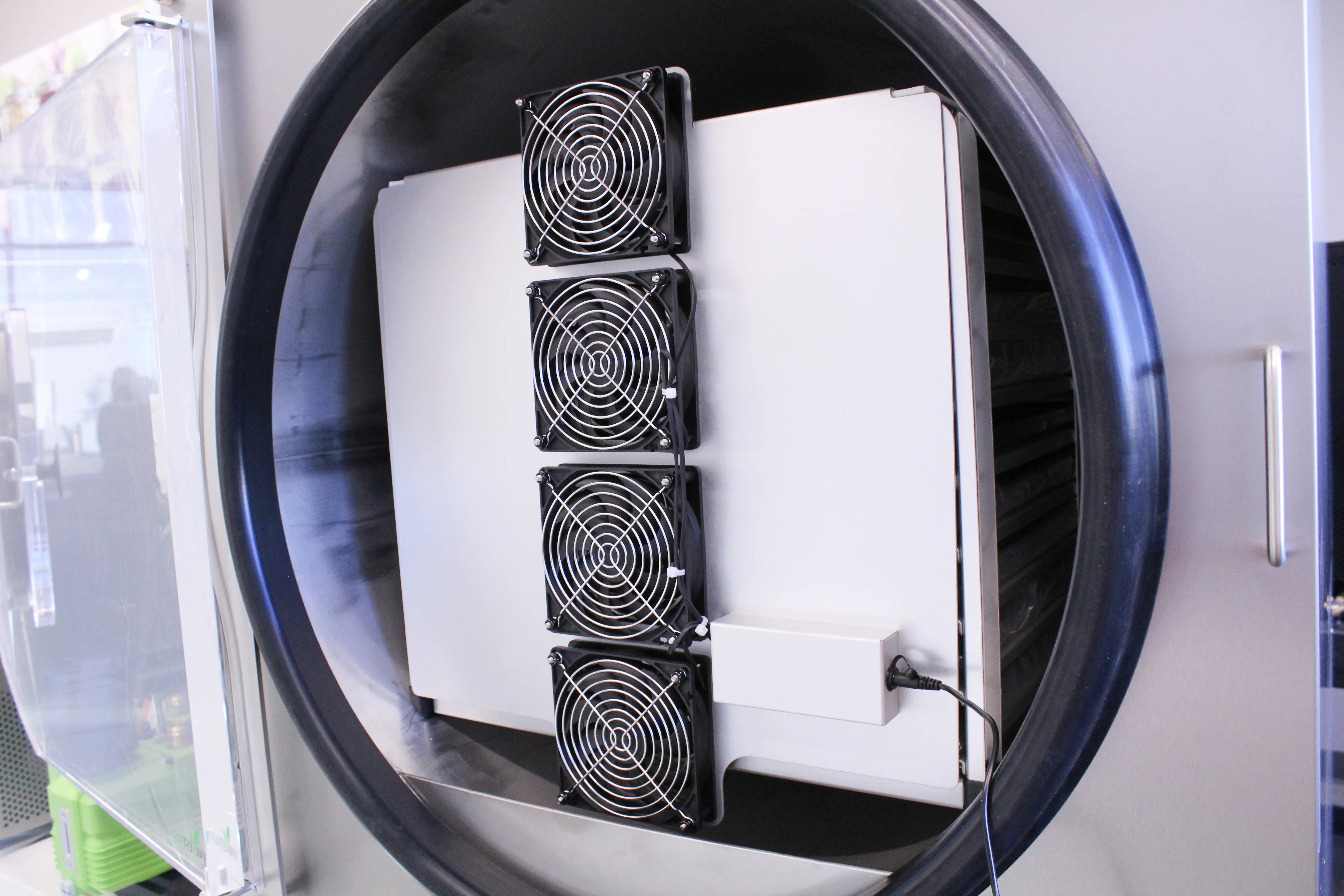 Commercial freeze dryer with door open showing internal fan grilles and duct assembly