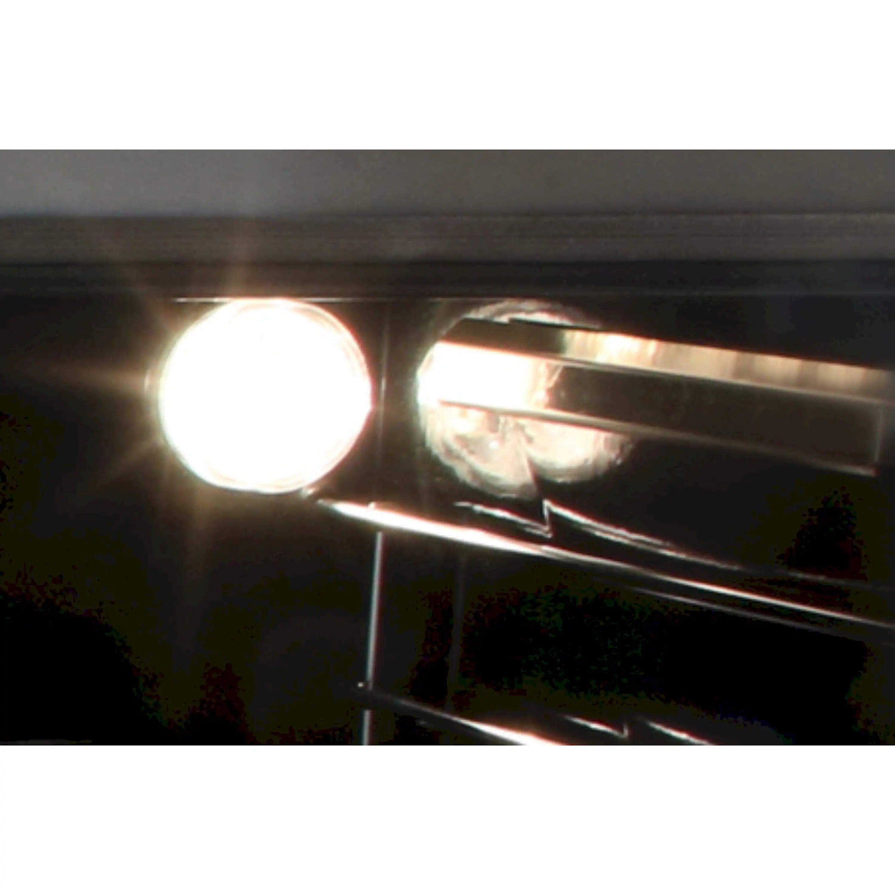 Oven light glowing under the range backsplash with control area partially visible