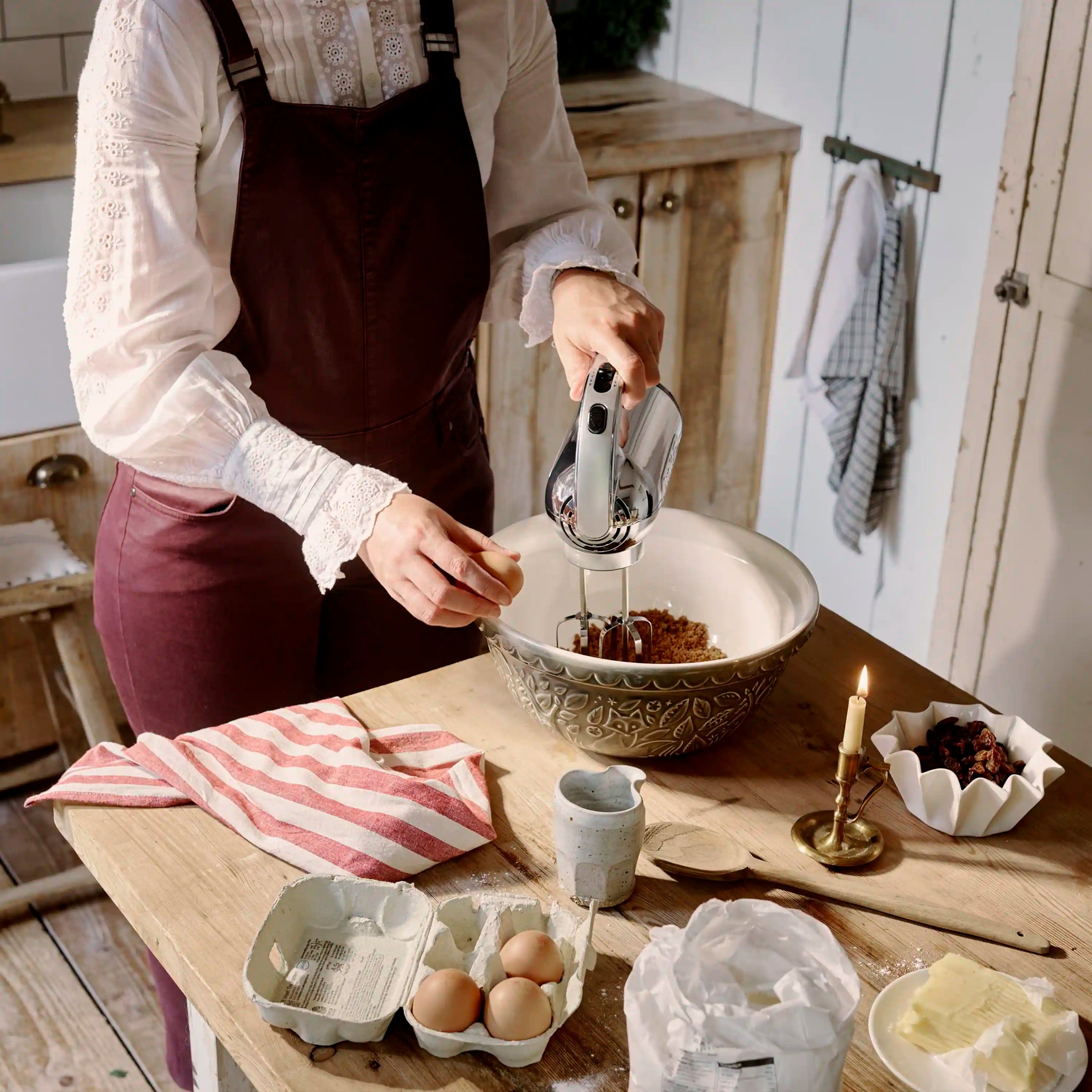 Polished chrome hand mixer in use, beaters stirring ingredients in mixing bowl