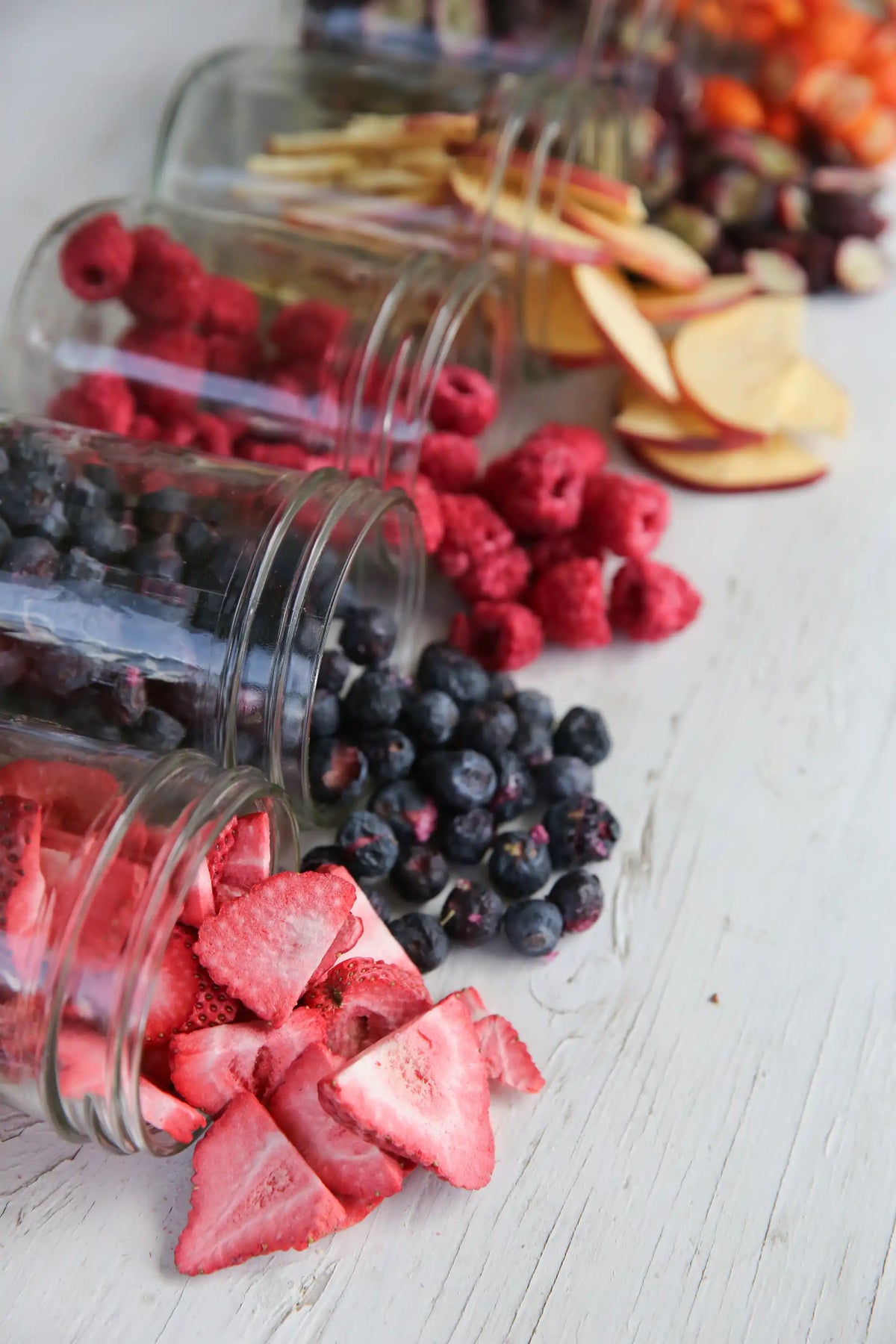Close-up of freeze-dried fruit and vegetables in clear jars on a table