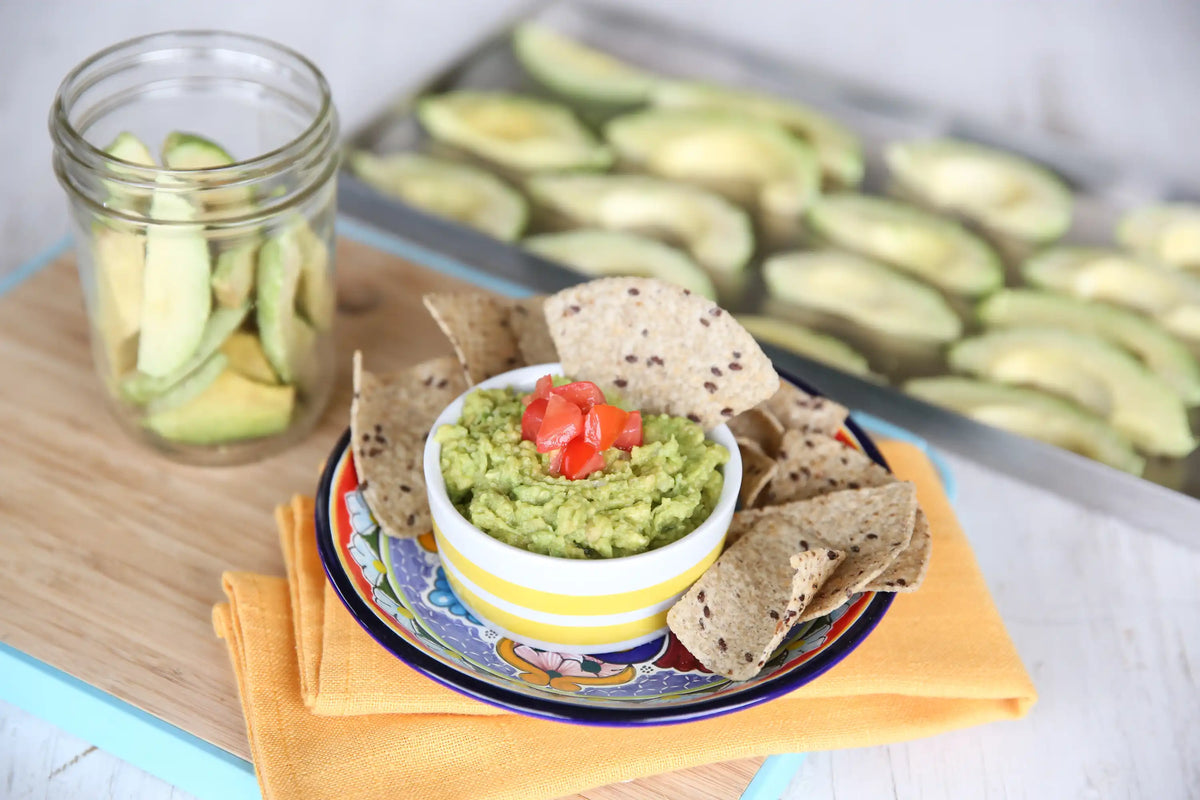 Freeze-dried food serving with crackers, green dip, and jar of sliced vegetables