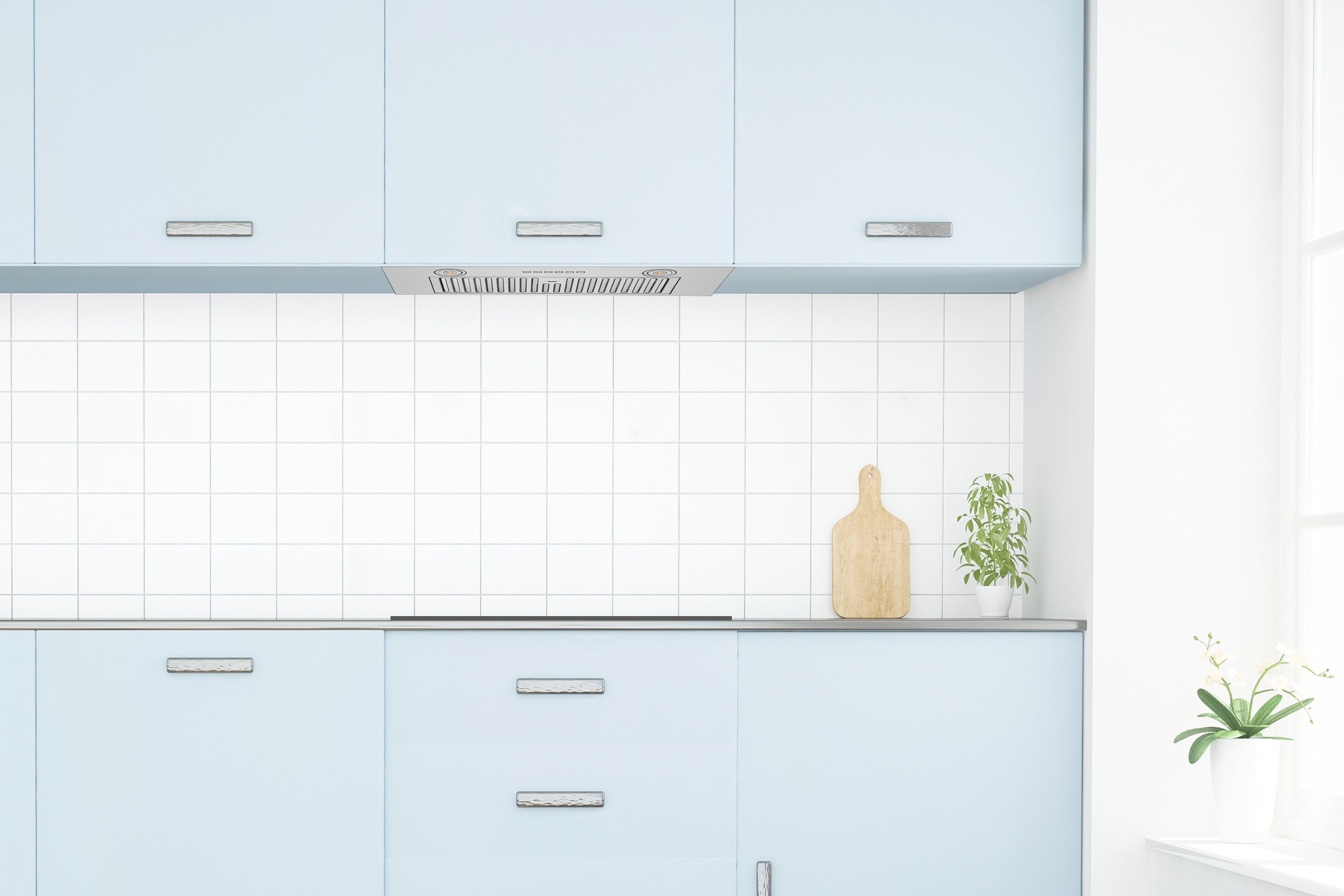 Recessed range hood insert installed under light blue cabinets