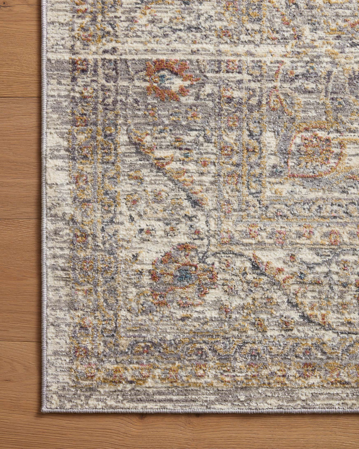 Stone-toned accent rug close-up edge with abstract multicolor distressed pattern