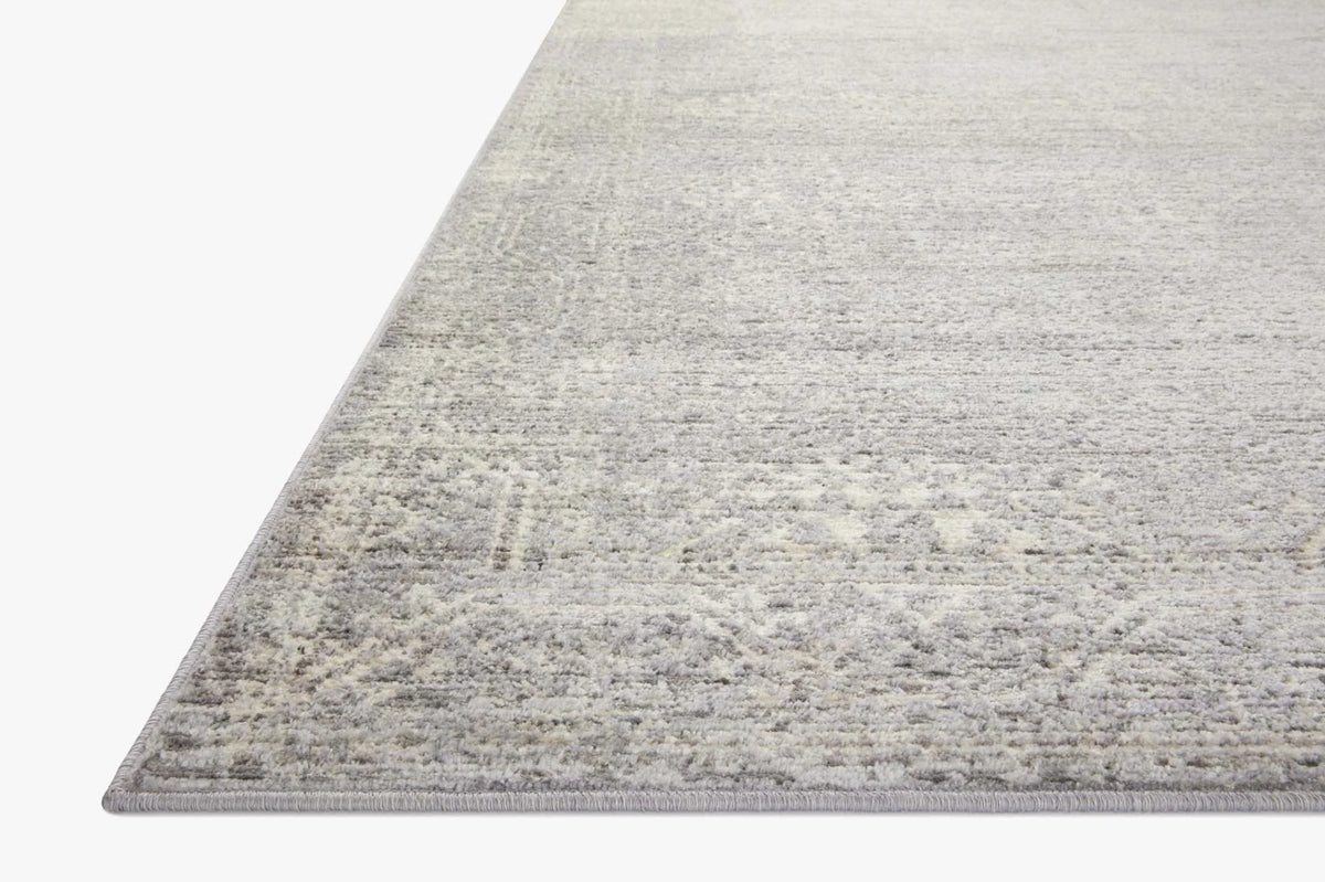 Silver and ivory contemporary area rug with distressed pattern, angled corner view