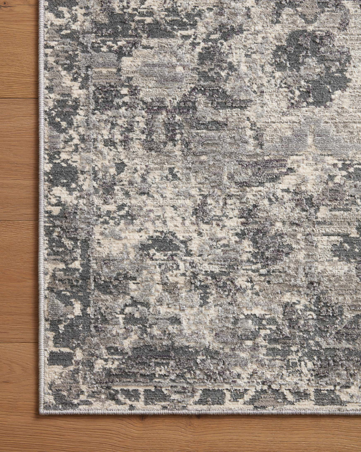 Charcoal and silver area rug close-up with distressed texture and subtle border