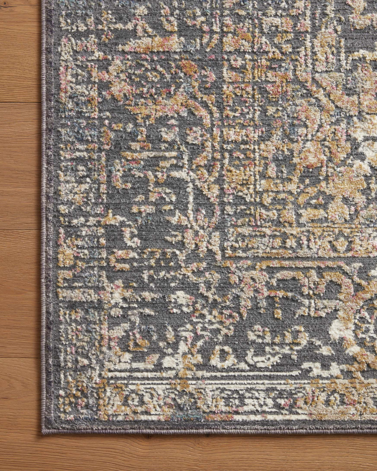 Corner of contemporary runner rug with multicolor distressed pattern and patterned border