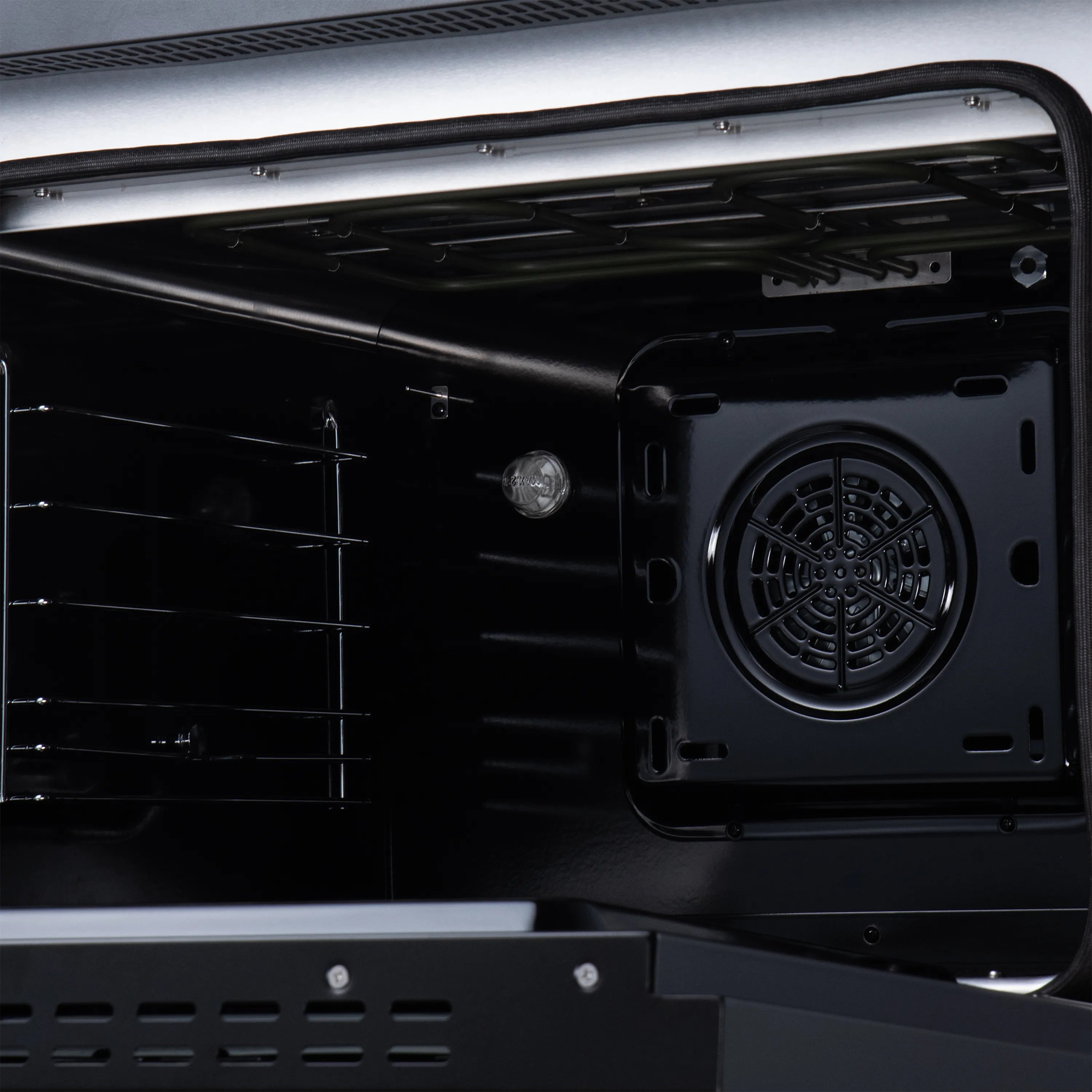 Black oven cavity with rear fan and convection vent, open range door