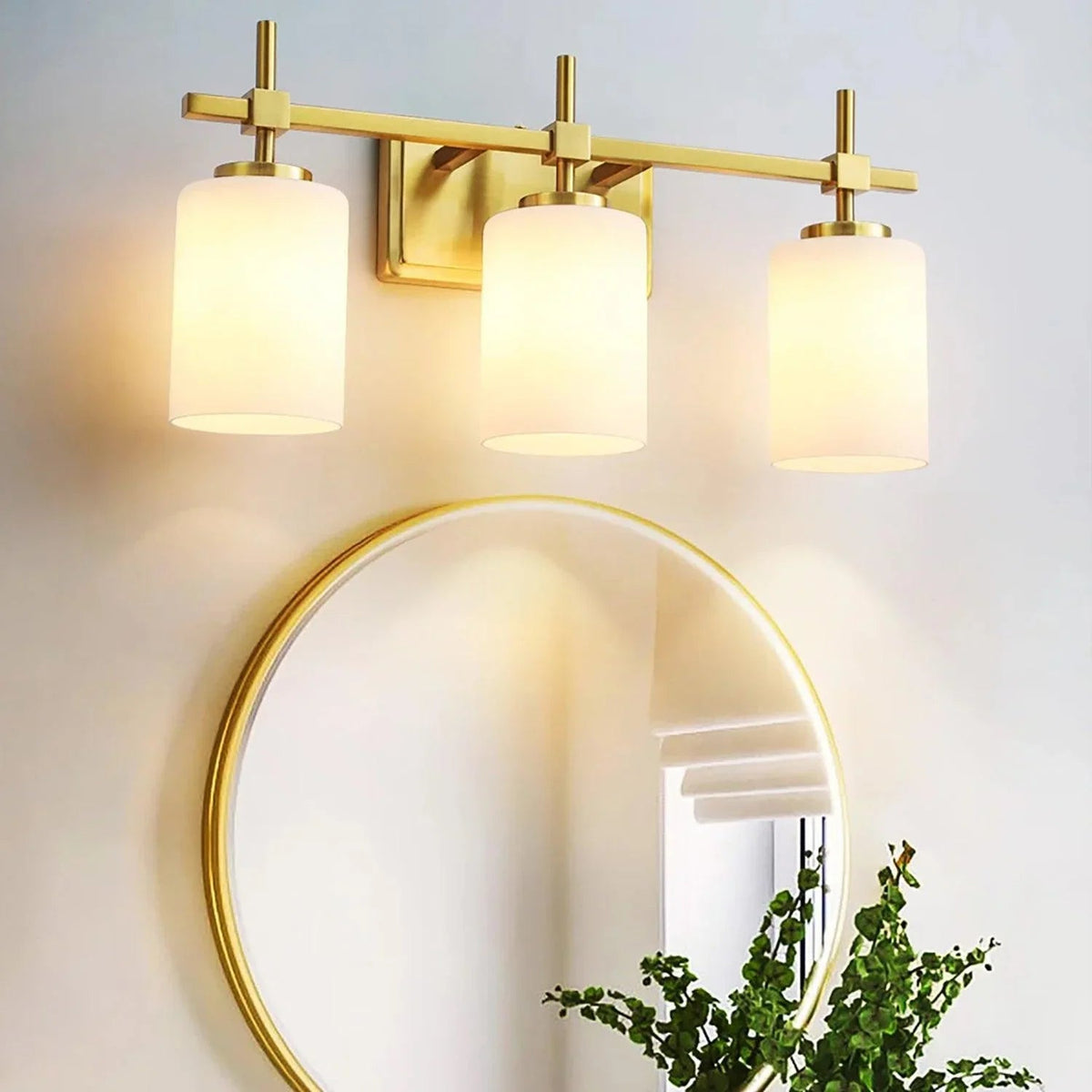 Golden modern 3-light vanity light with frosted glass shades and squared backplate