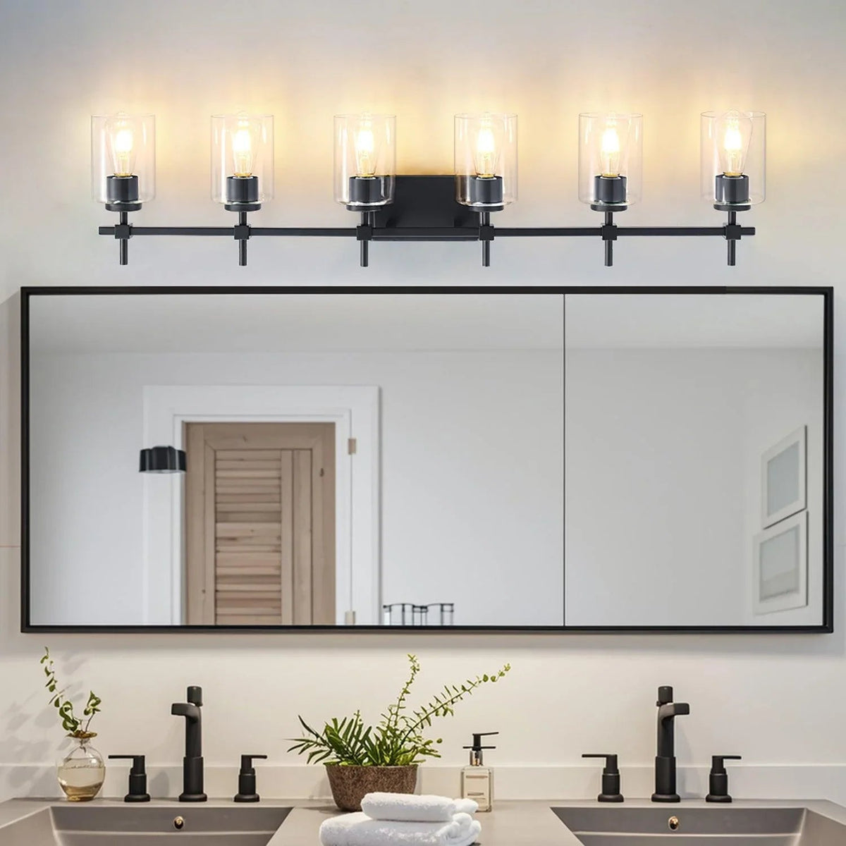 Bathroom vanity light with six clear glass shades on a black metal bar