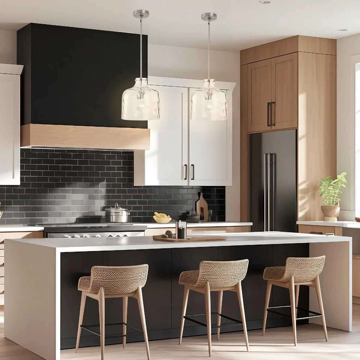 Island pendant light set with clear textured glass shades over kitchen island, brushed metal