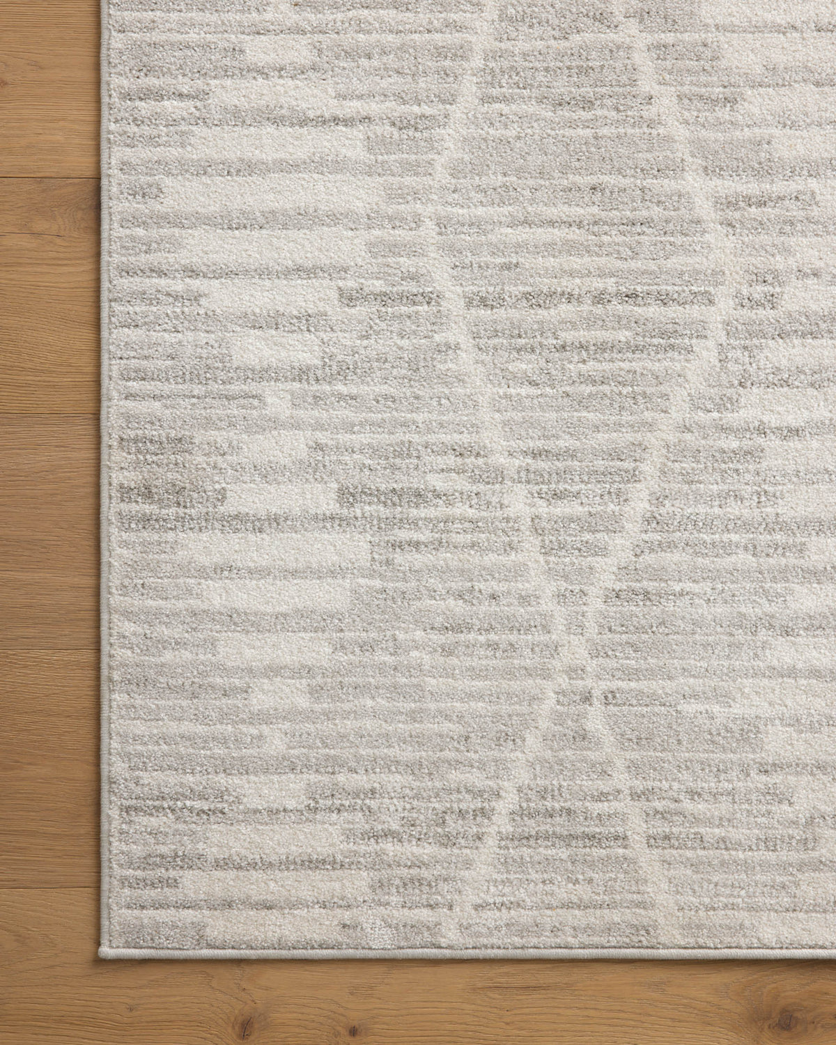 Ivory and silver area rug with detailed geometric stripe texture along border