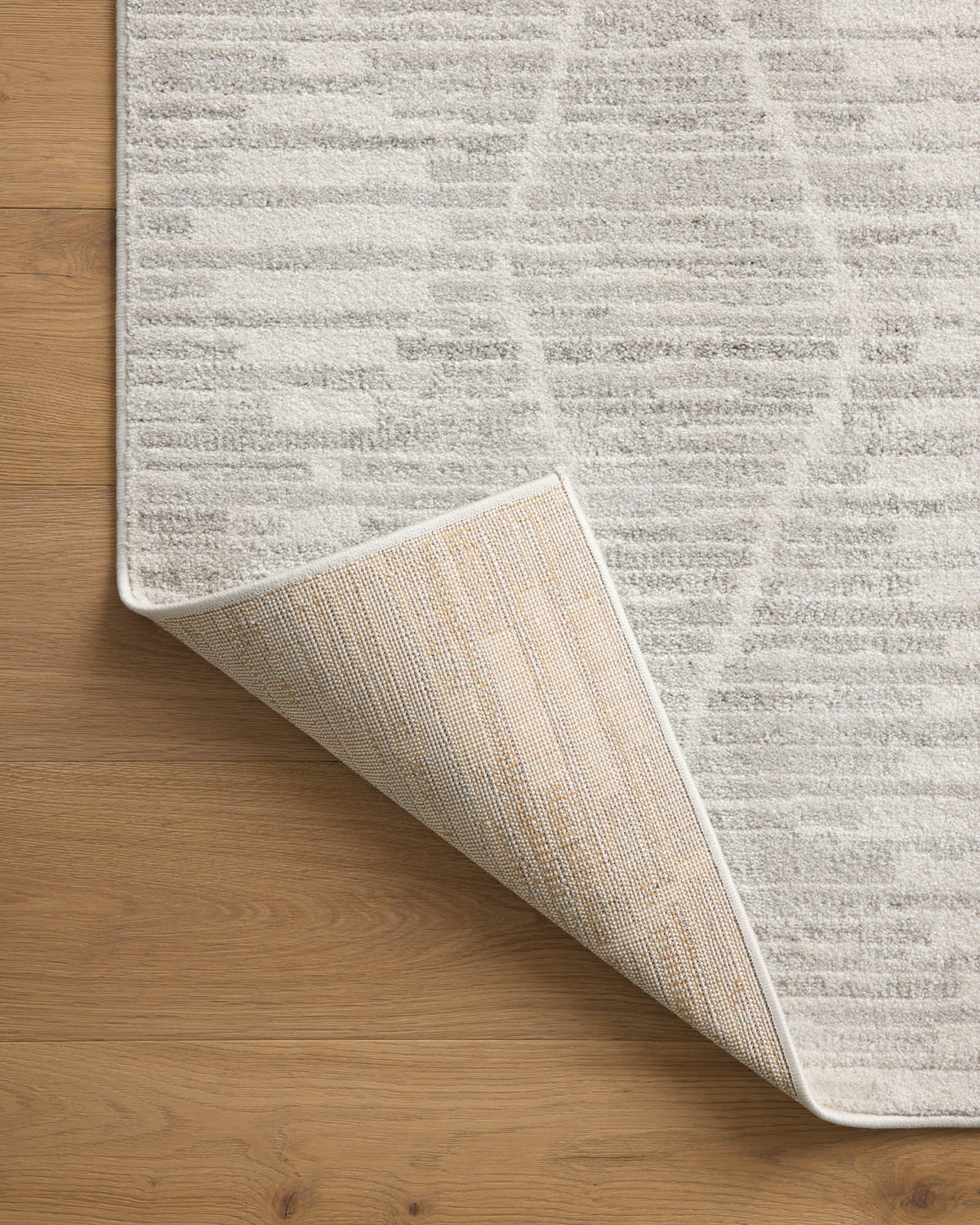 Ivory and silver area rug rolled edge showing woven underside and stitched border