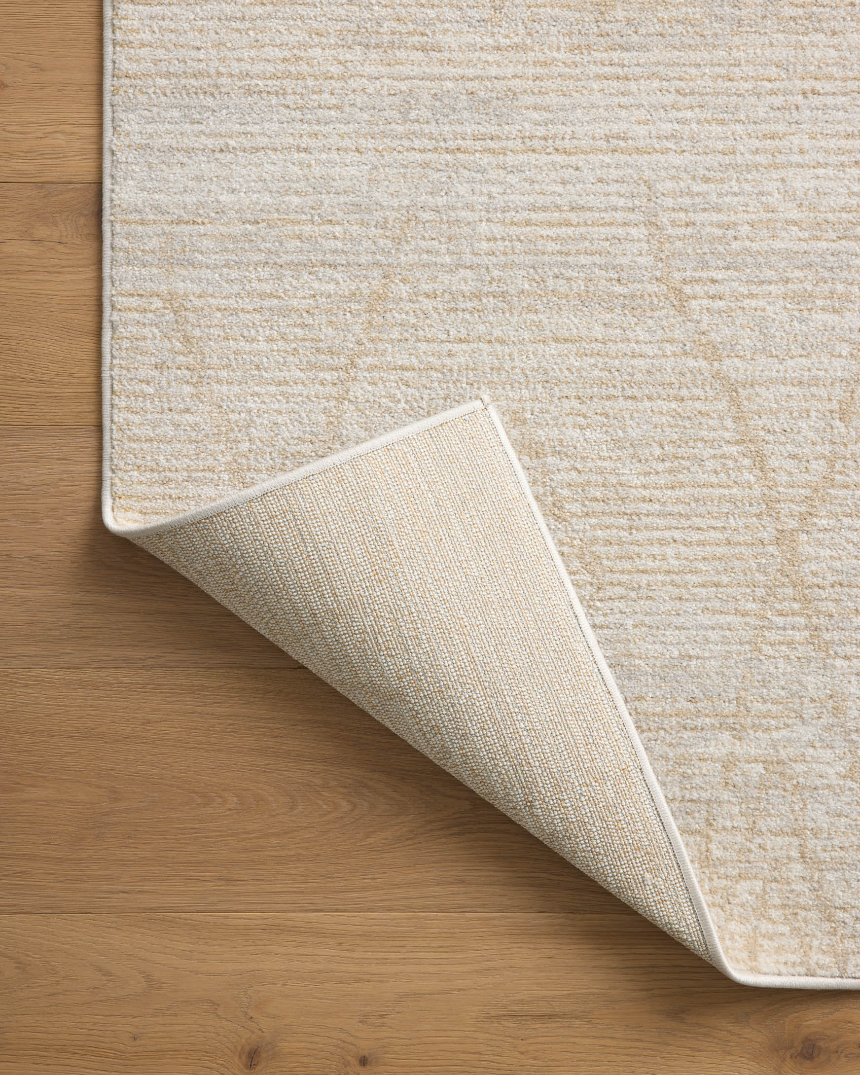 Natural and mist rug detail with folded corner, textured low-pile surface