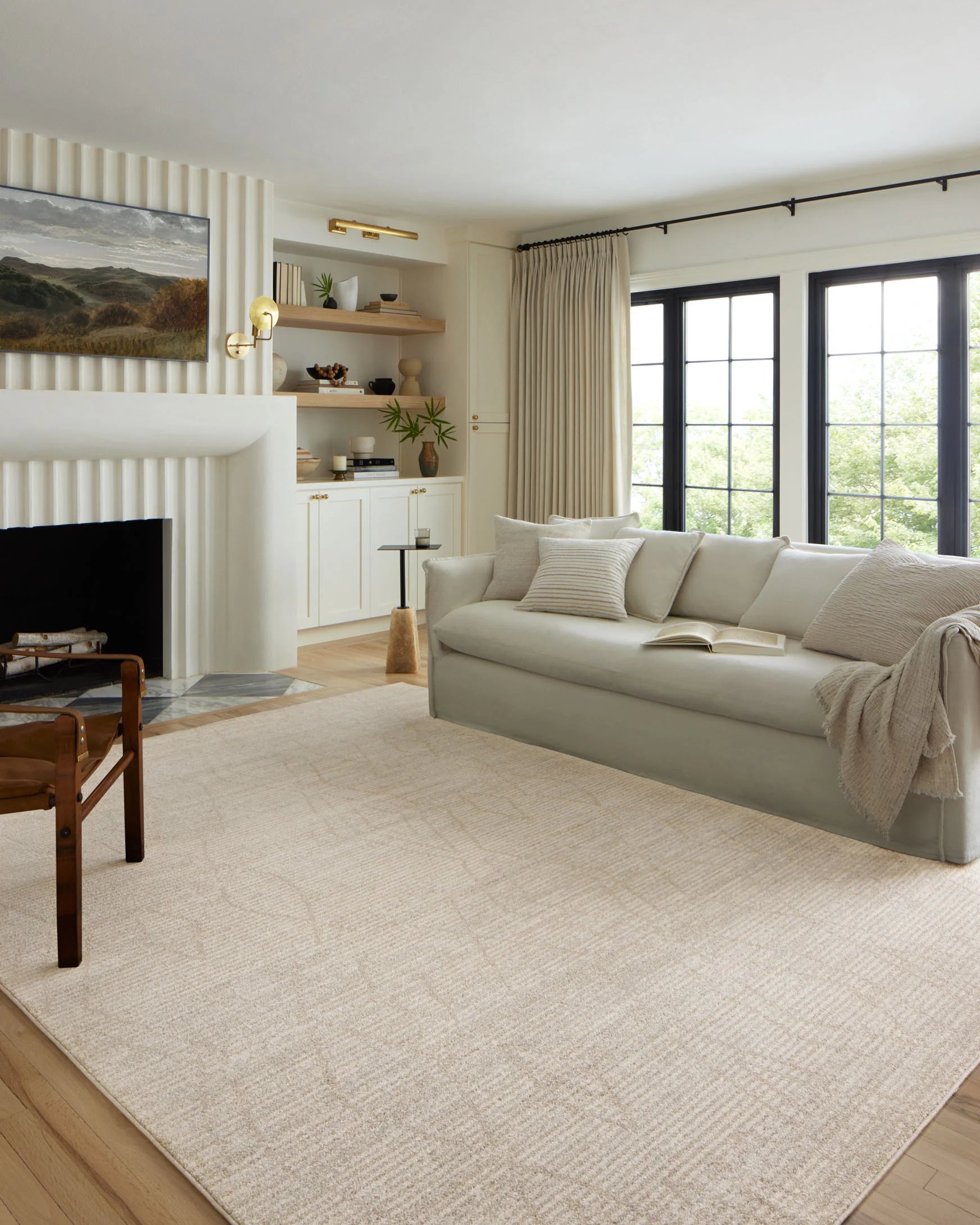 Light beige area rug with subtle geometric pattern, shown laid on hardwood flooring