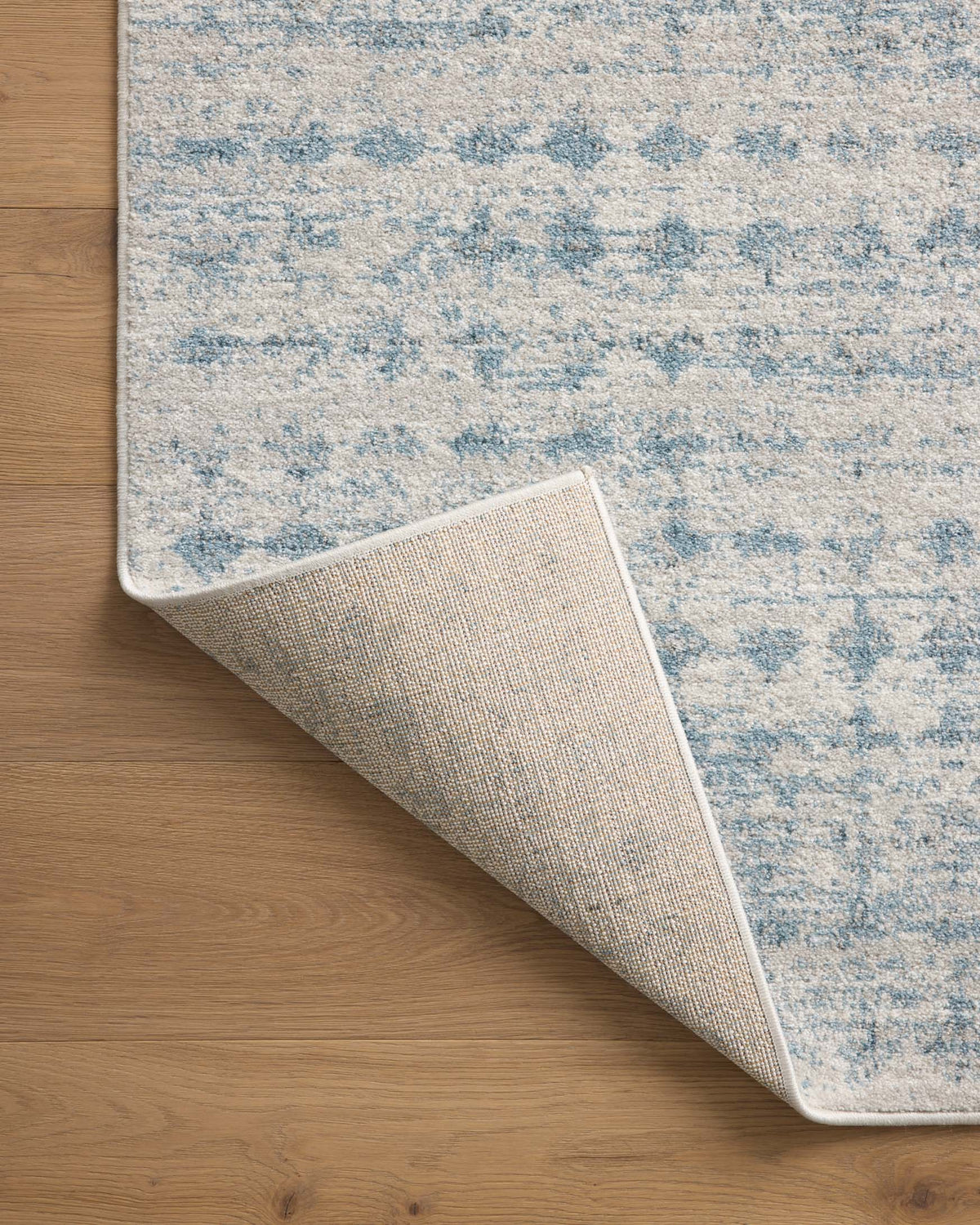 Area rug with reversible backing, showing flat weave thickness