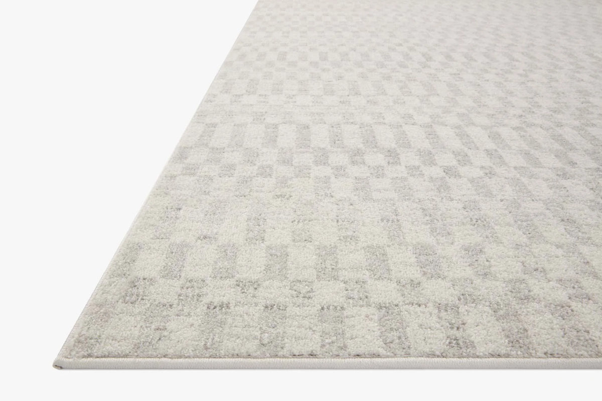 Ivory and light gray area rug with subtle geometric pattern, low pile, serged border.