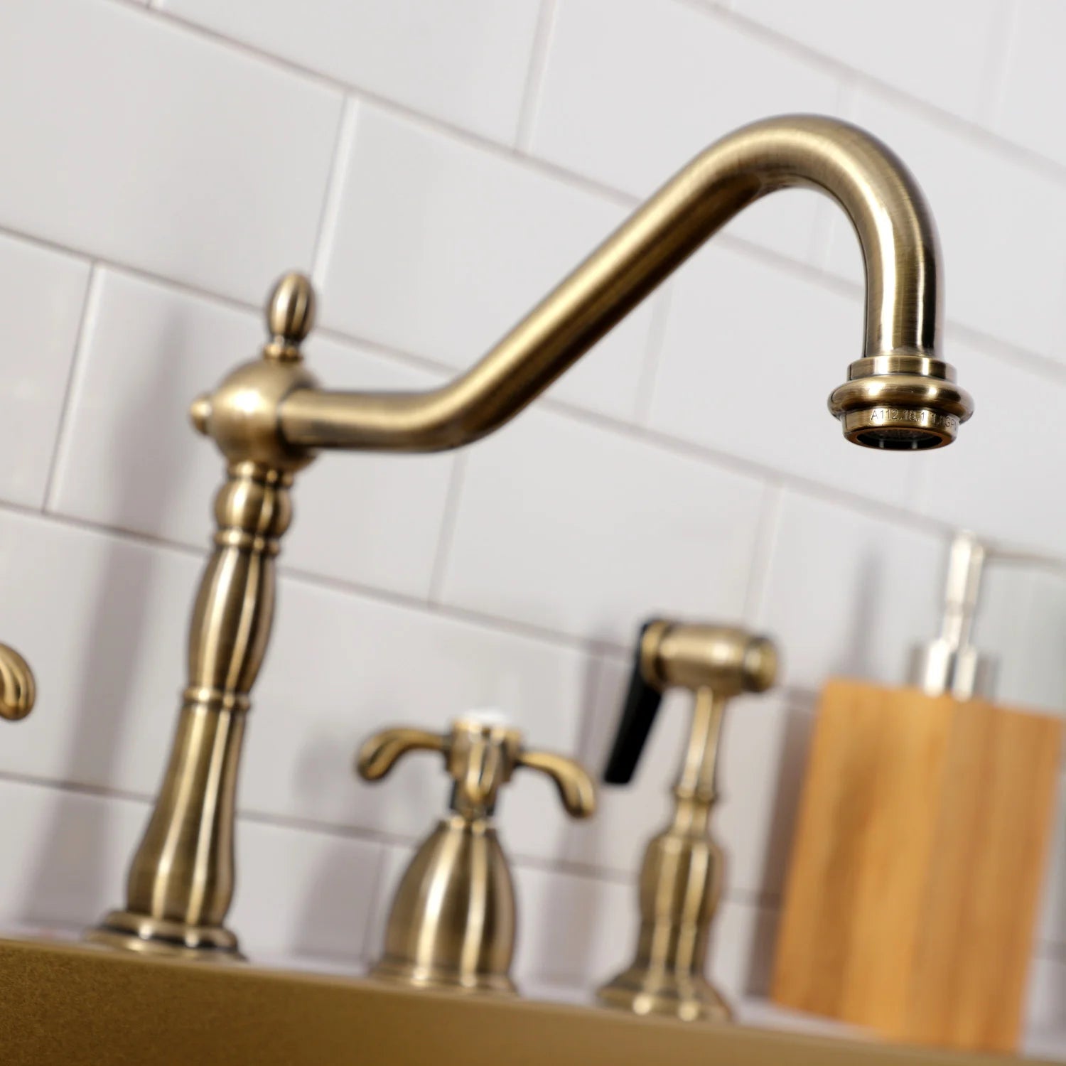 Antique brass gooseneck kitchen faucet with deck handles and detachable sprayer
