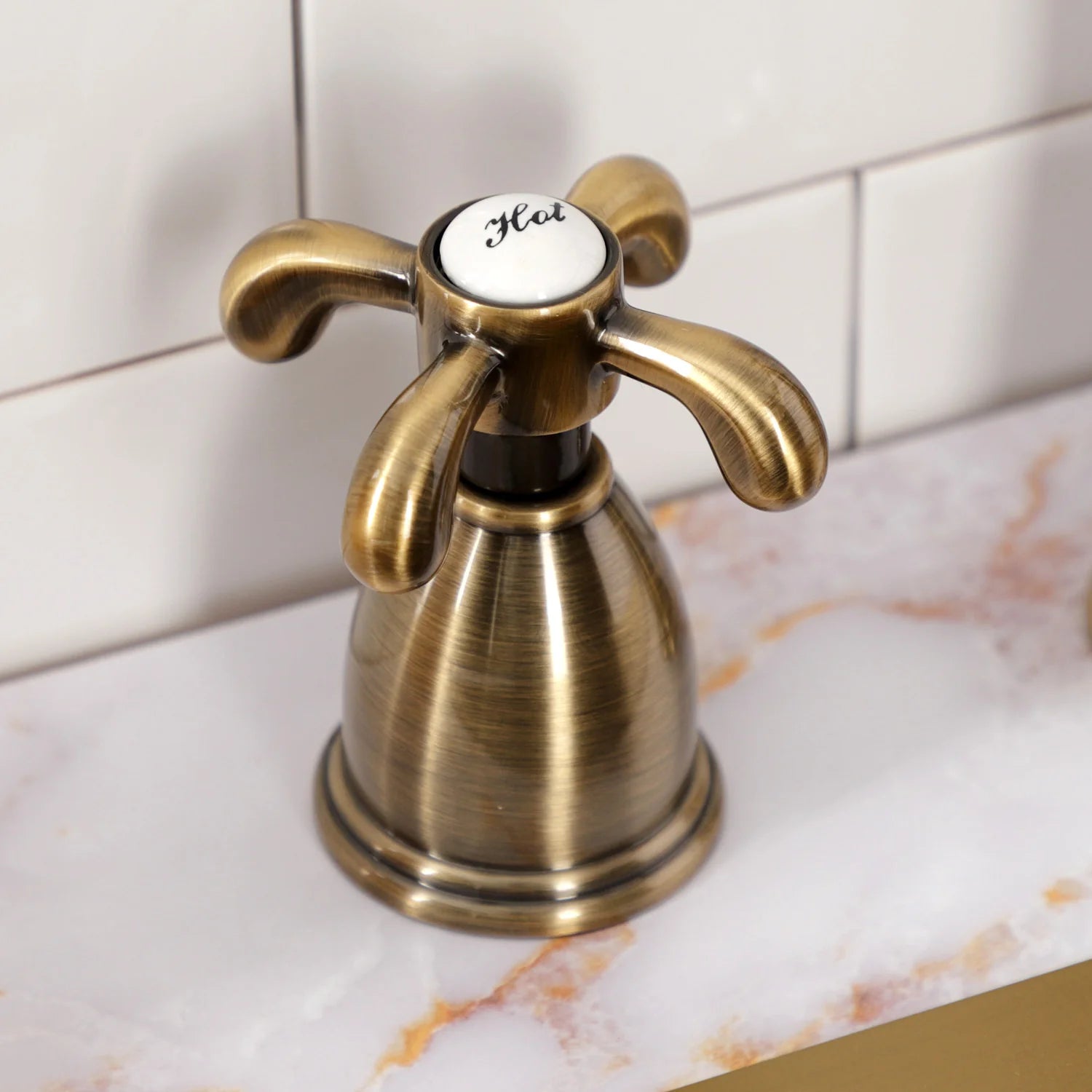 Antique brass deck-mount kitchen faucet with curved lever handles and control knob
