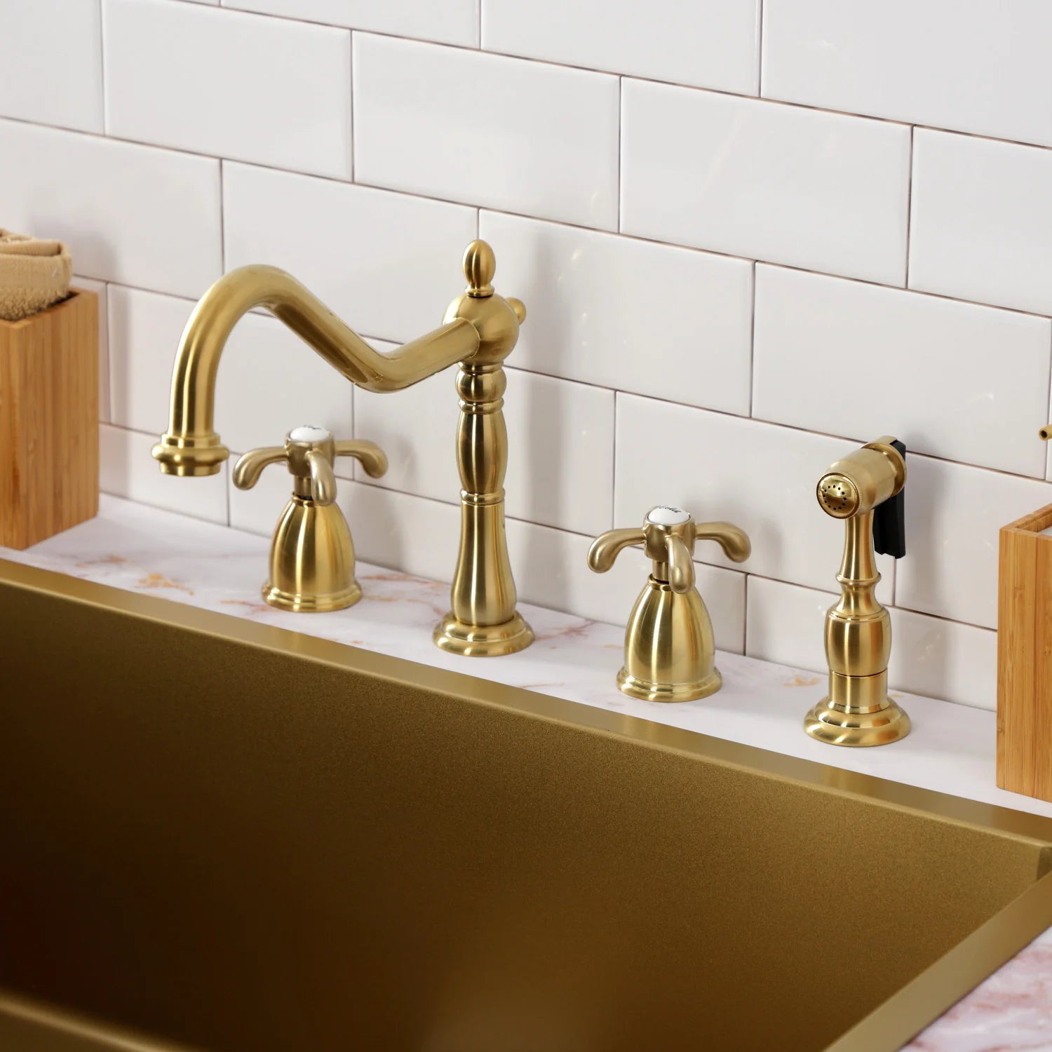 Brushed brass widespread kitchen faucet with two handles and deck sprayer