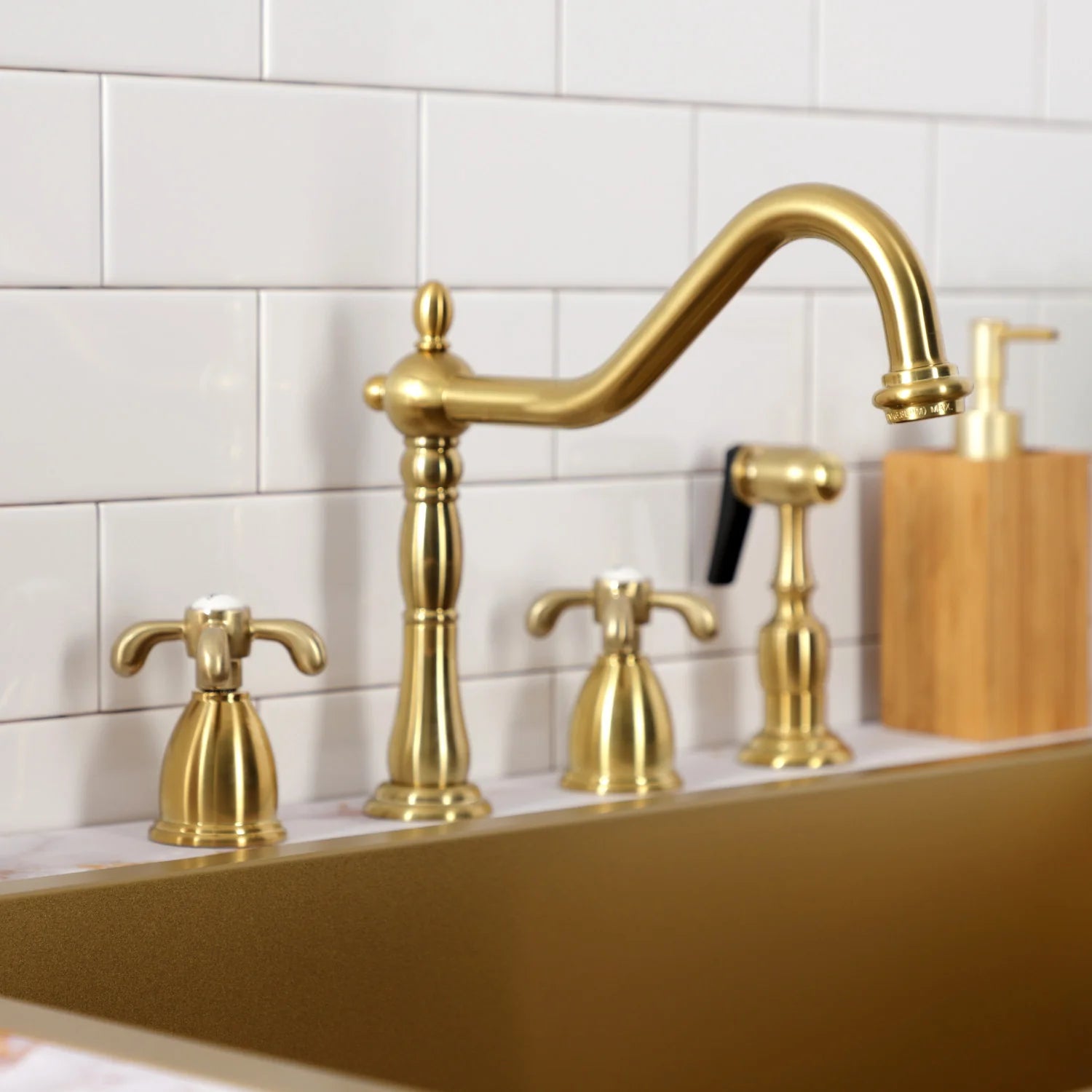 Brushed brass widespread faucet set with arch spout, deck handles, and sprayer