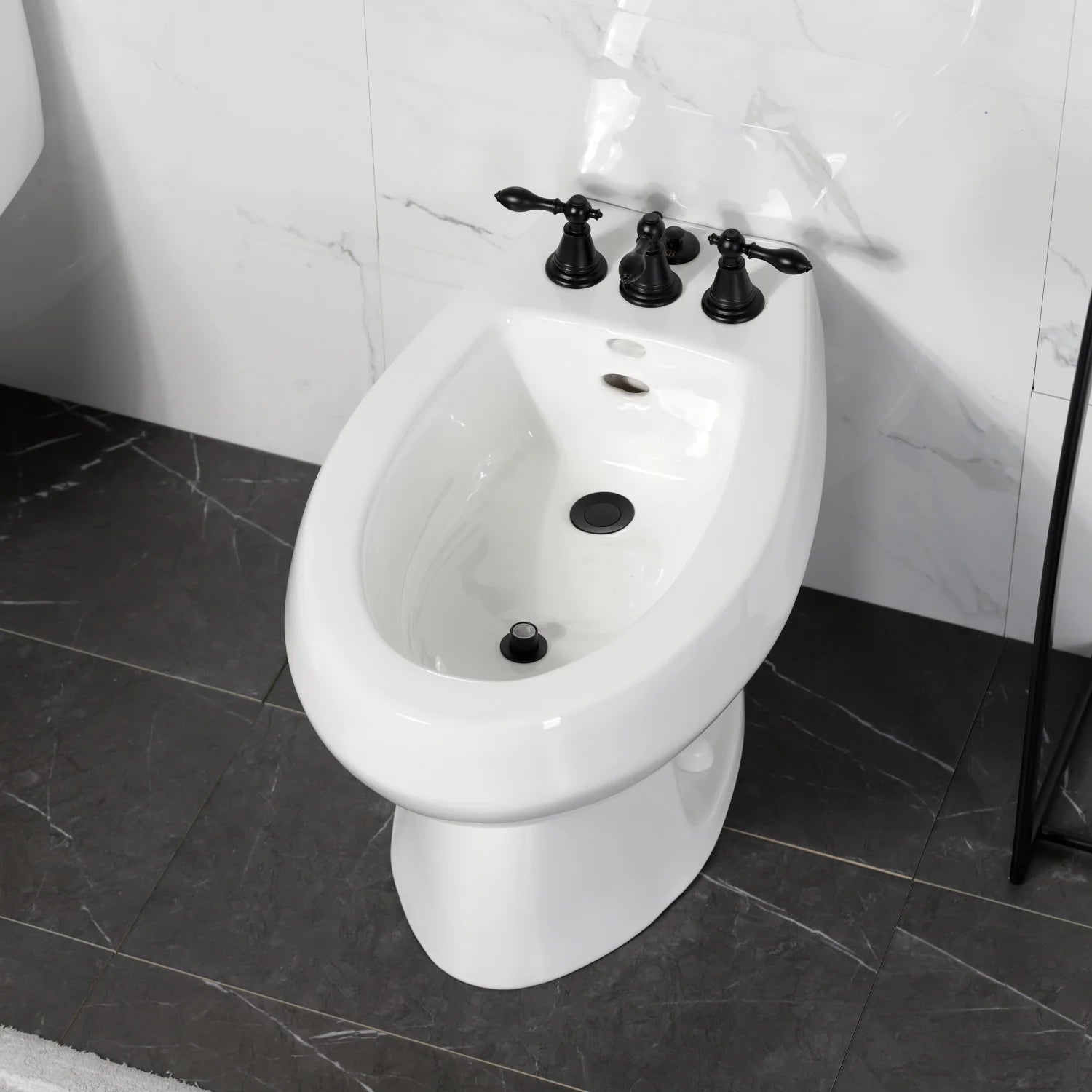 Matte black three-handle bidet faucet on a white bidet toilet