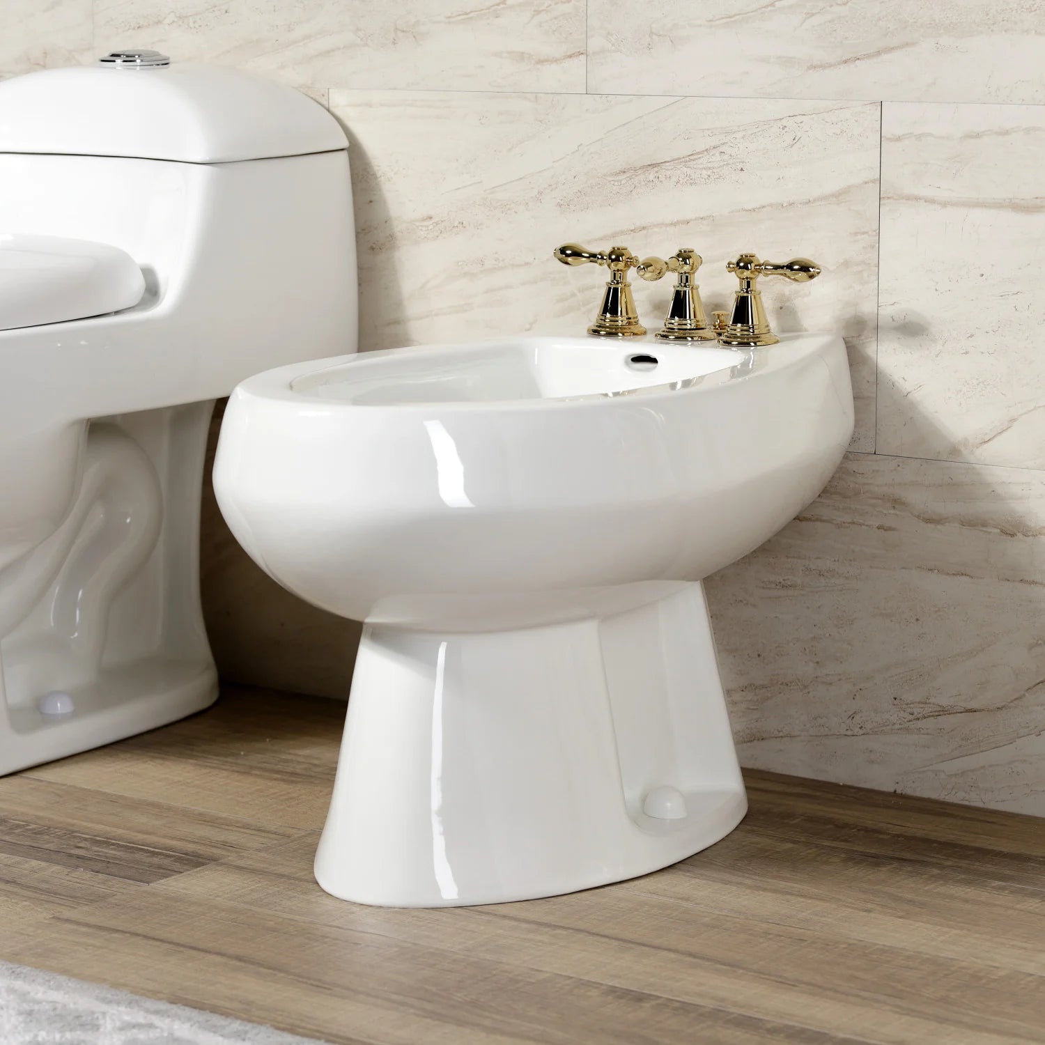 Polished brass three-handle bidet faucet with center spout on white sink