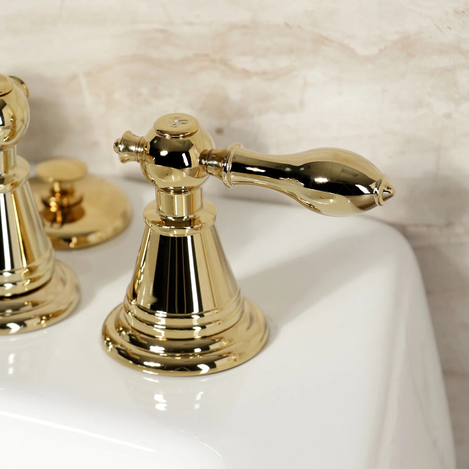 Polished brass three-handle bidet faucet with curved spout and round base
