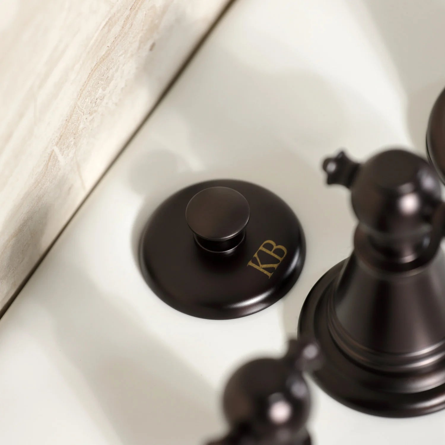 Oil-rubbed bronze faucet handle and circular escutcheon with “KR” engraving