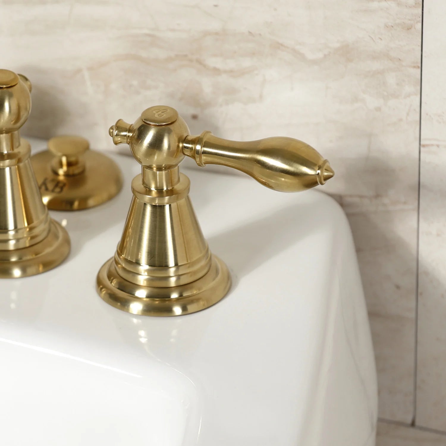 Brushed brass three-handle bidet faucet with curved spout and pop-up