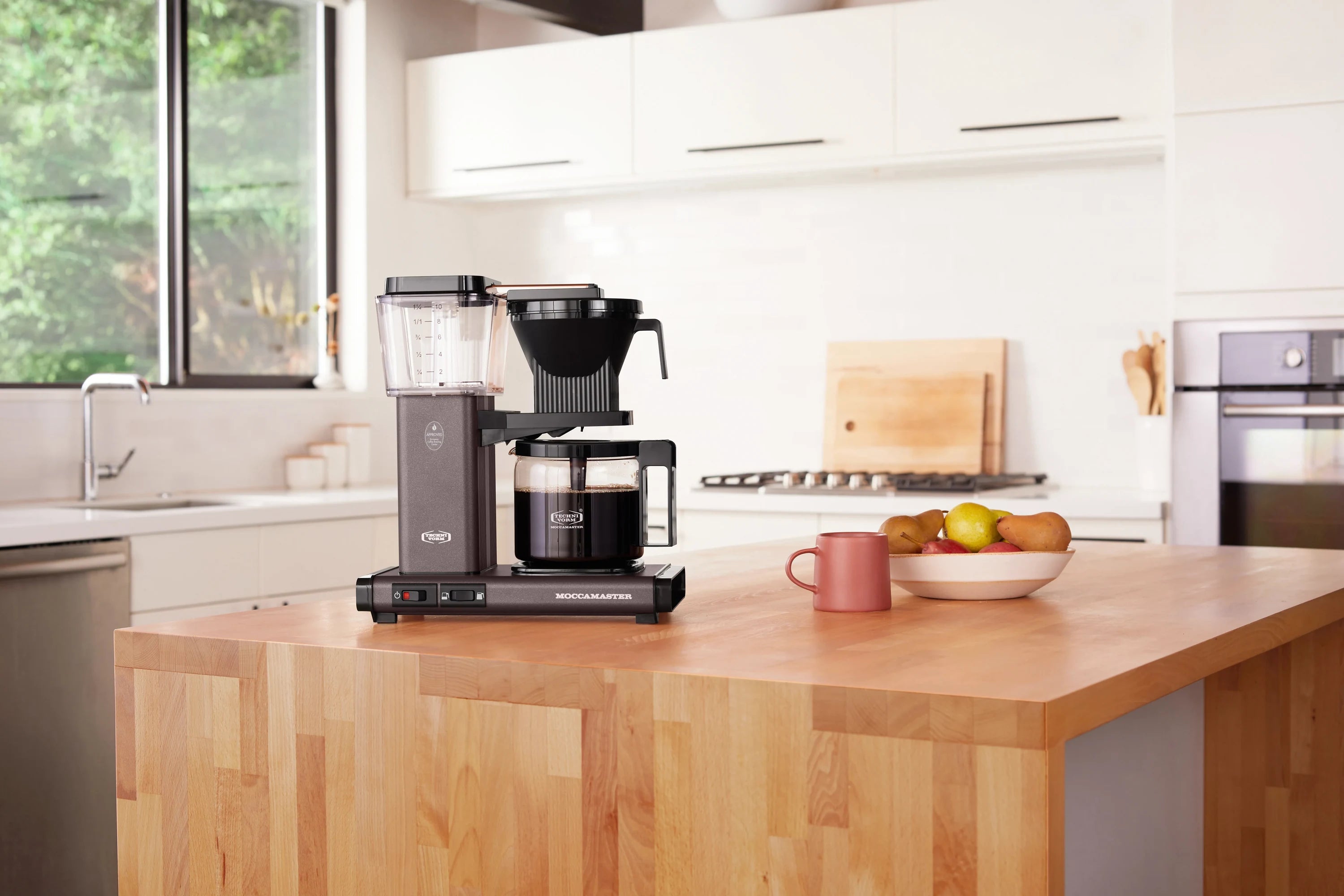 Stone grey and black drip coffee maker on kitchen countertop with glass carafe