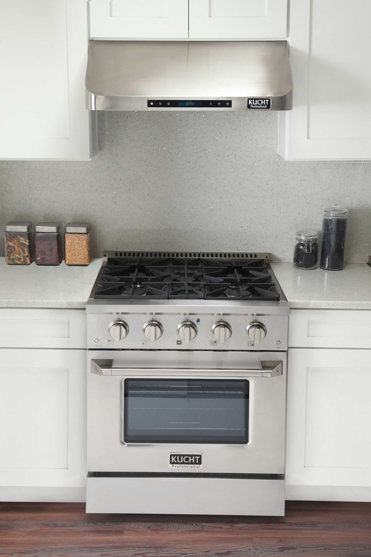 Stainless Kucht dual fuel range installed in kitchen with open hood above and oven front