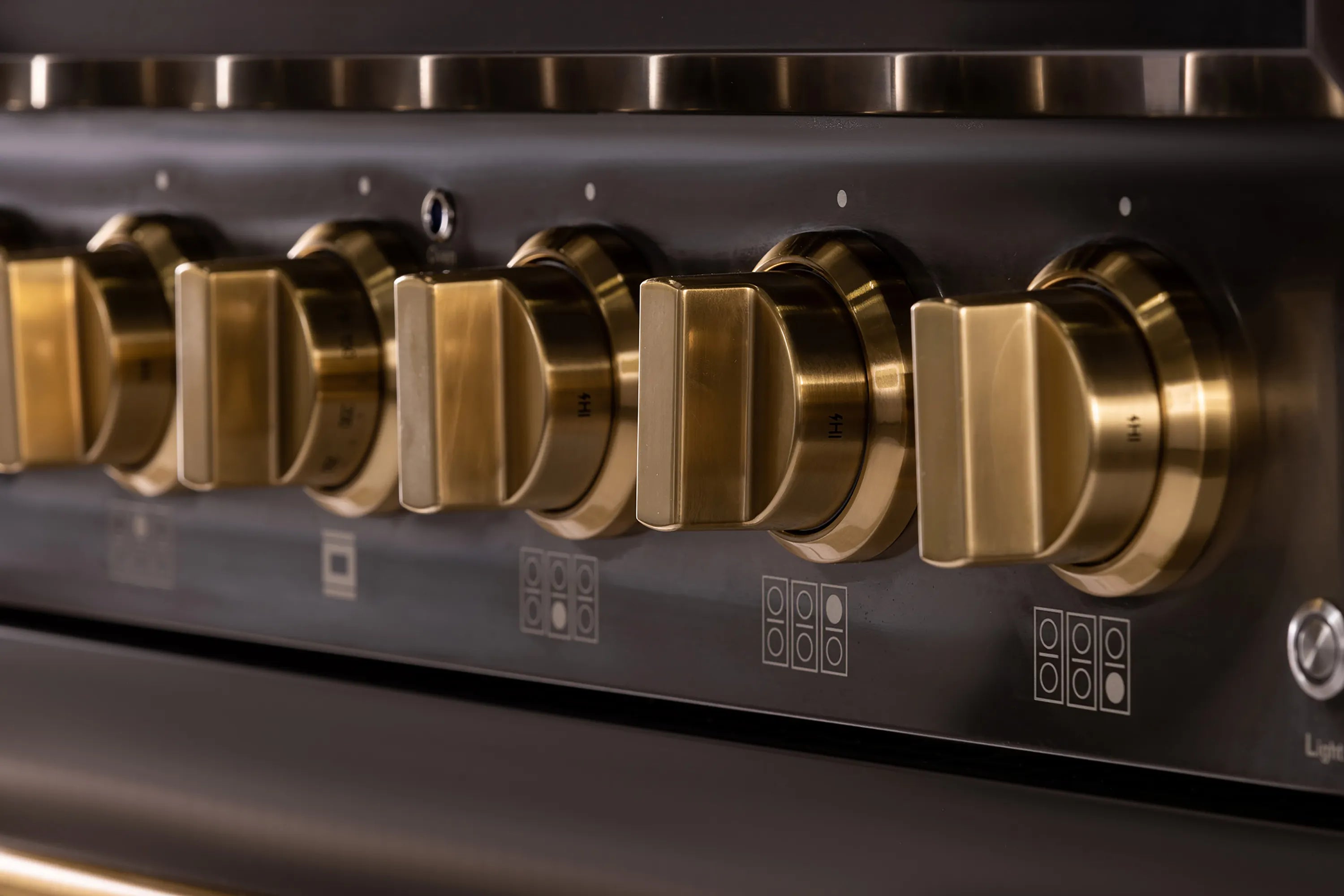 Gold control knobs on titanium stainless cooktop for dual fuel range