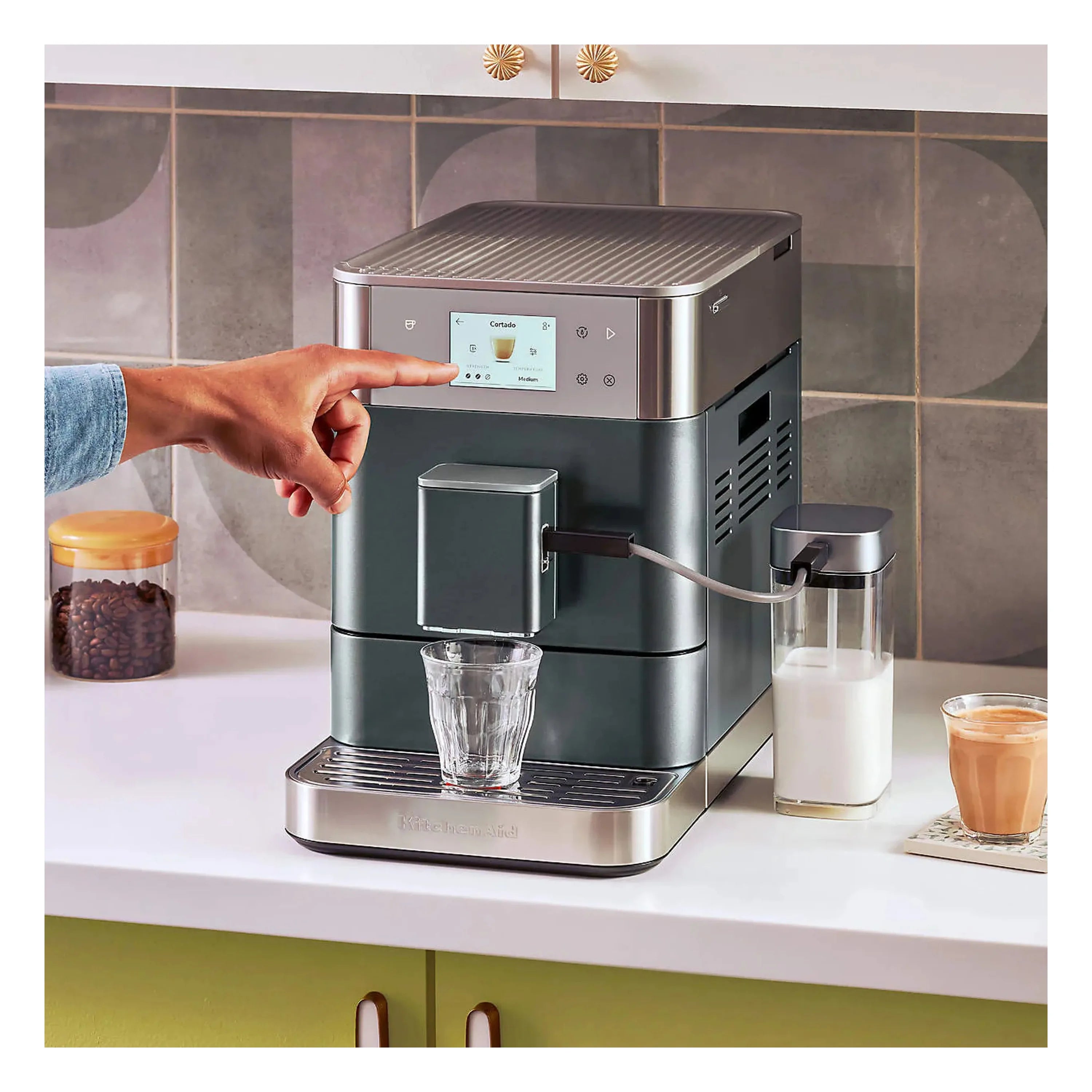 Juniper green fully automatic espresso machine on countertop with cup and milk jug