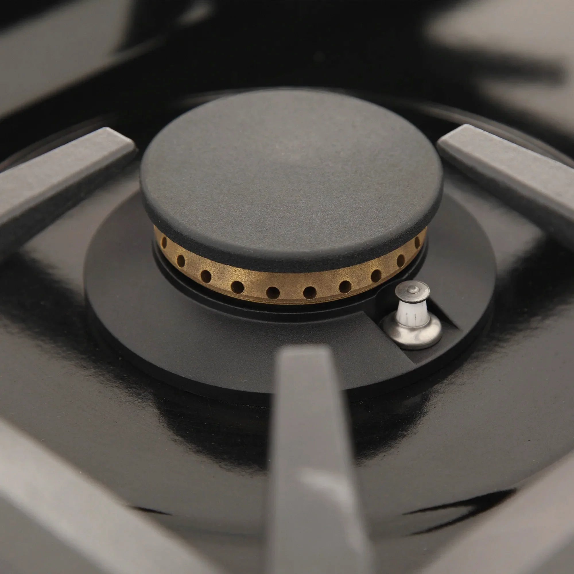 Gas range burner with round black cap and surrounding cast iron burner ring