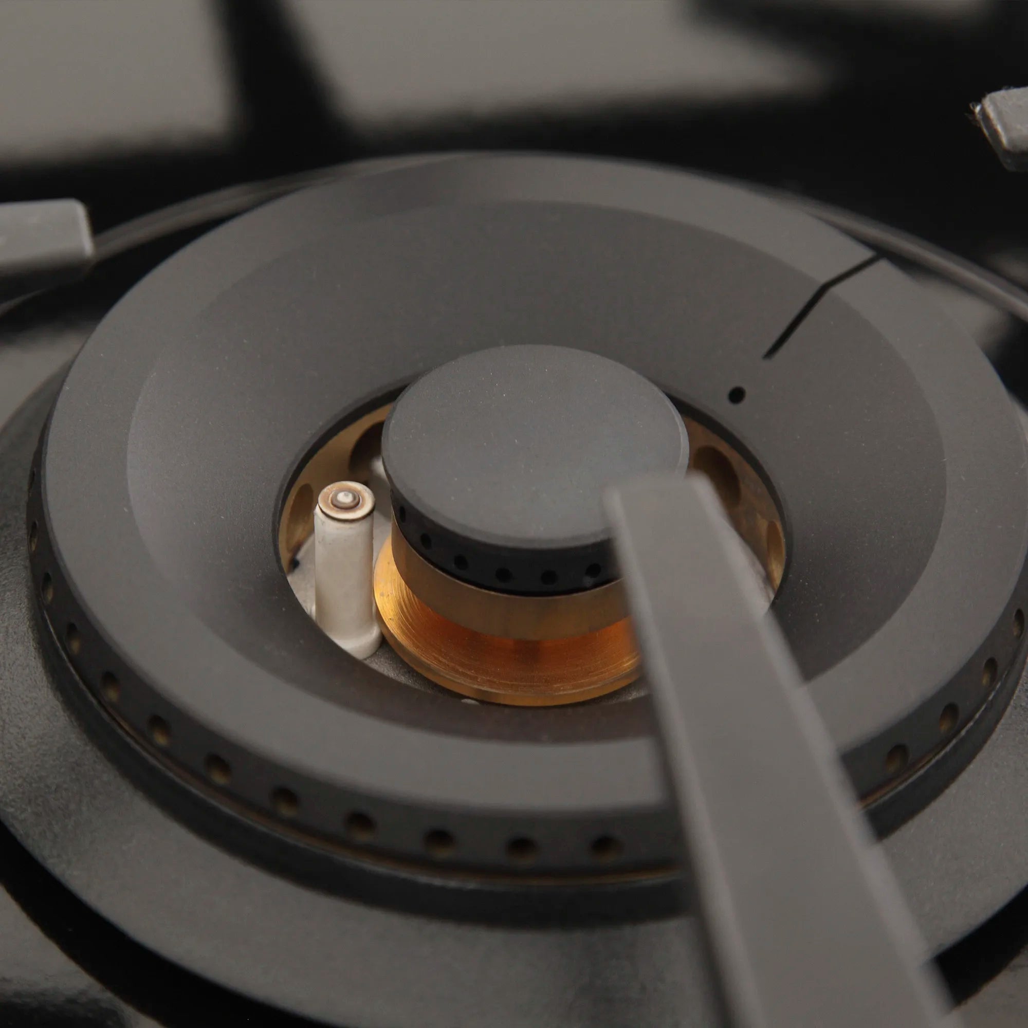 Black gas cooktop burner with copper ports and central cap