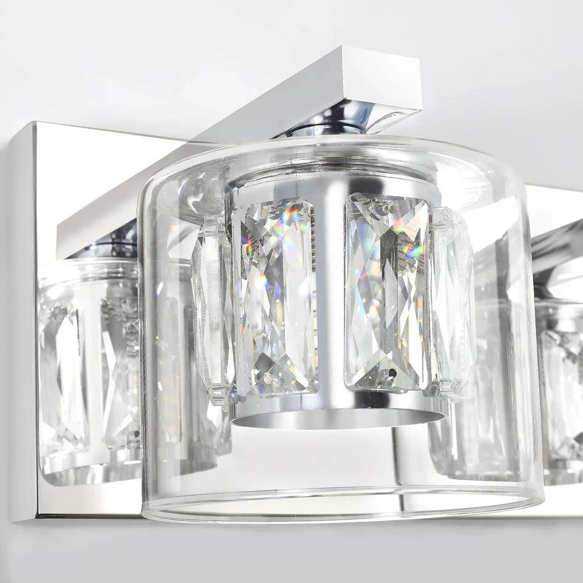 Close-up of chrome 5-light vanity light with faceted crystal glass shade and metal base.