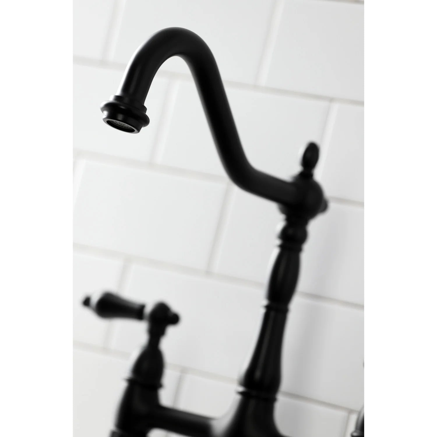 Matte black bridge kitchen faucet close-up of arched spout and handle